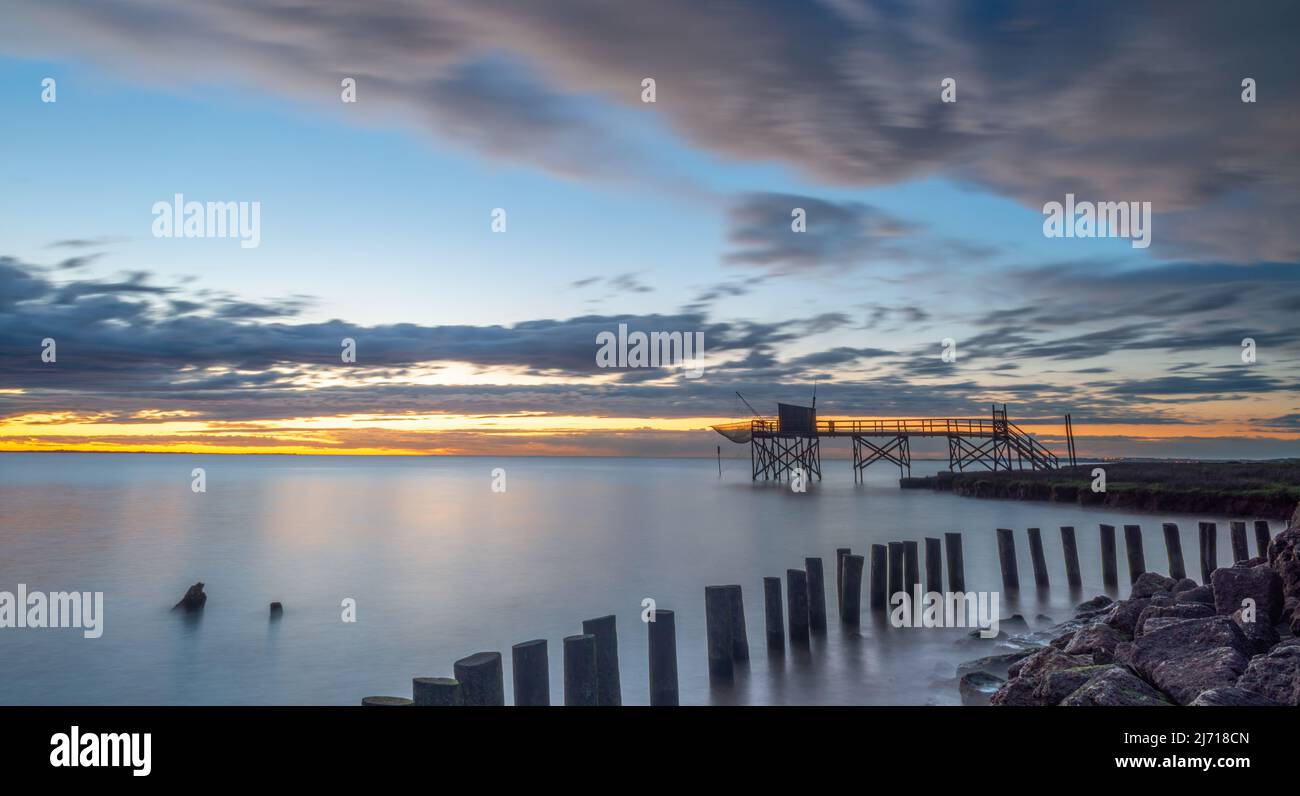 Gironde estuary, Charente Maritime, France wooden groynes and fishing hut on stilts at sunset west Atlantic coast France Stock Photo