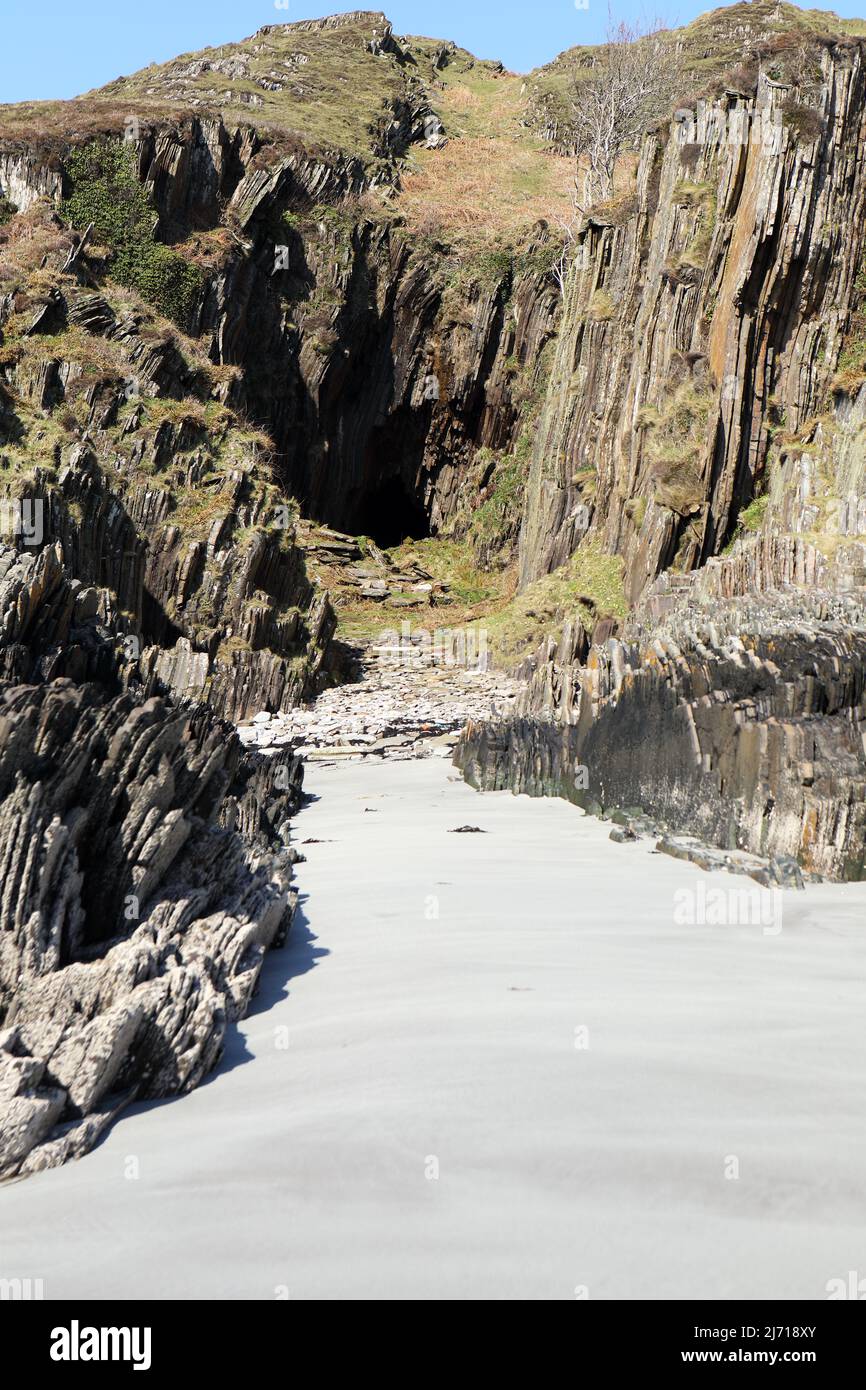 Sandy beach and entrance to Scoor Cave on the Isle of Mull in Scotland Stock Photo