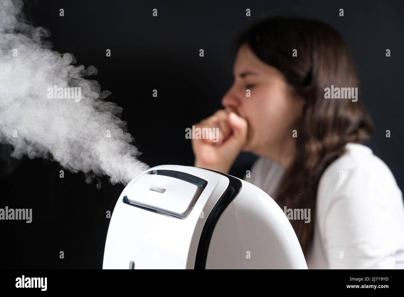 Humidifier and coughing woman in the background. Humidification of the