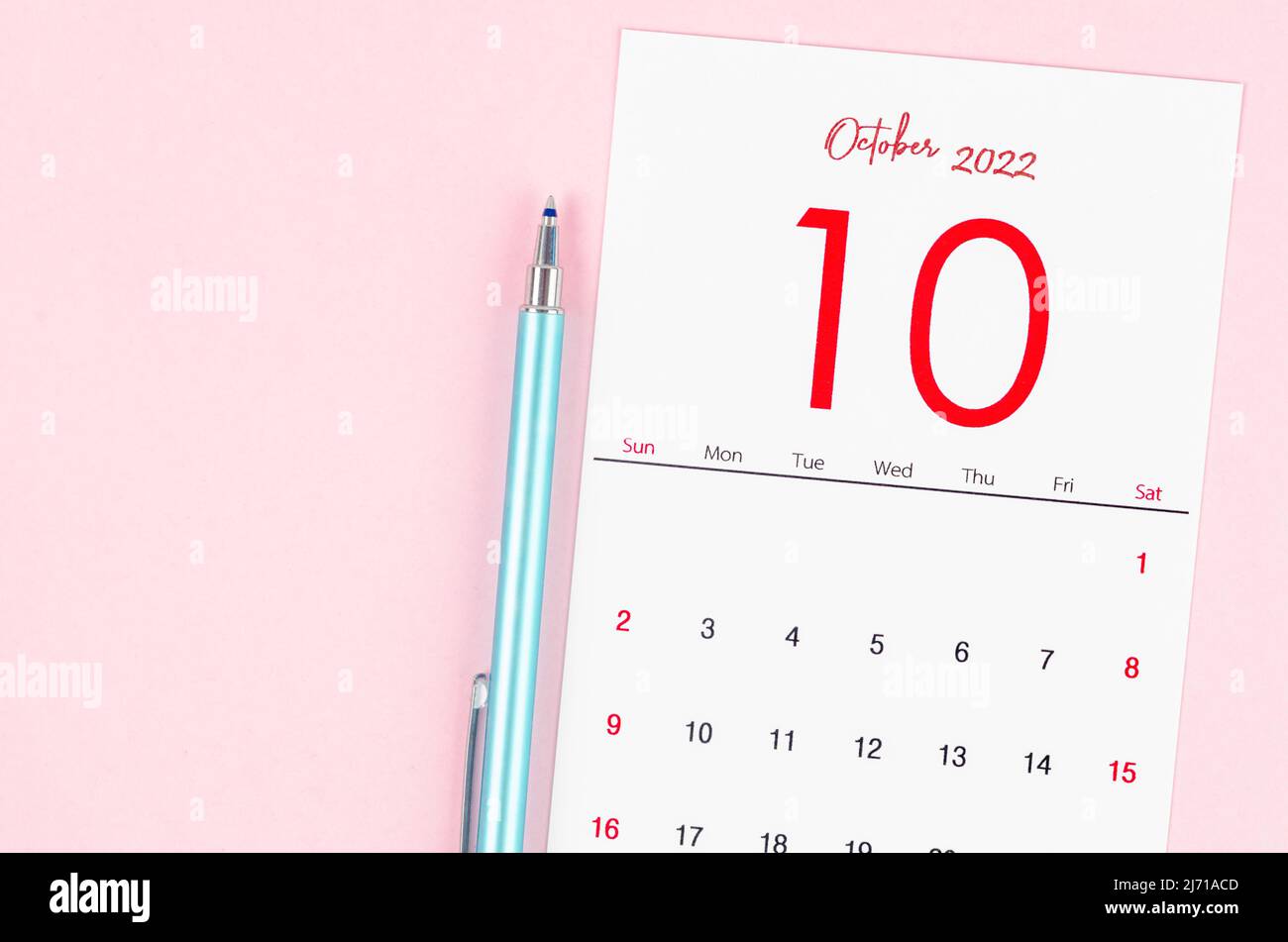 The October 2022 calendar with pen on pink background. Stock Photo