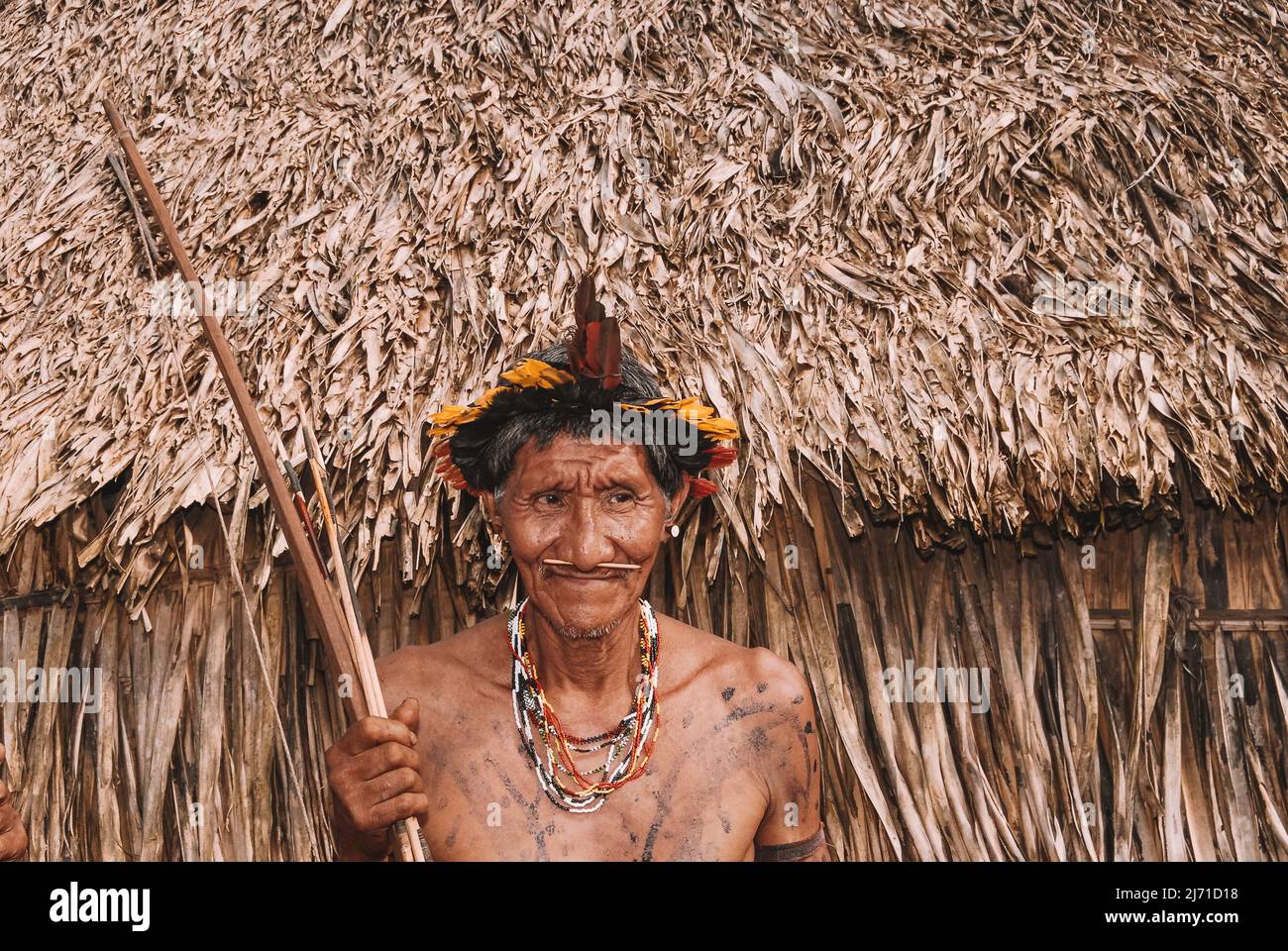 Indigenous man wearing a headdress know as cocar, leader of Arara do Laranjal tribe, near Xingu River in the Brazilian Amazon. 2007. Stock Photo
