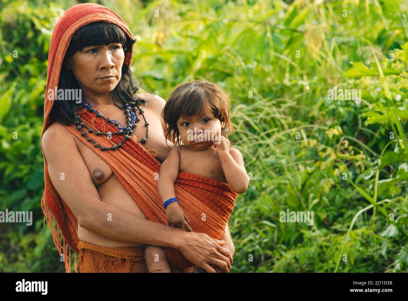 Indian mother from the Arawete Amazon tribe in Brazil carrying baby on a sling, 2007. Stock Photo
