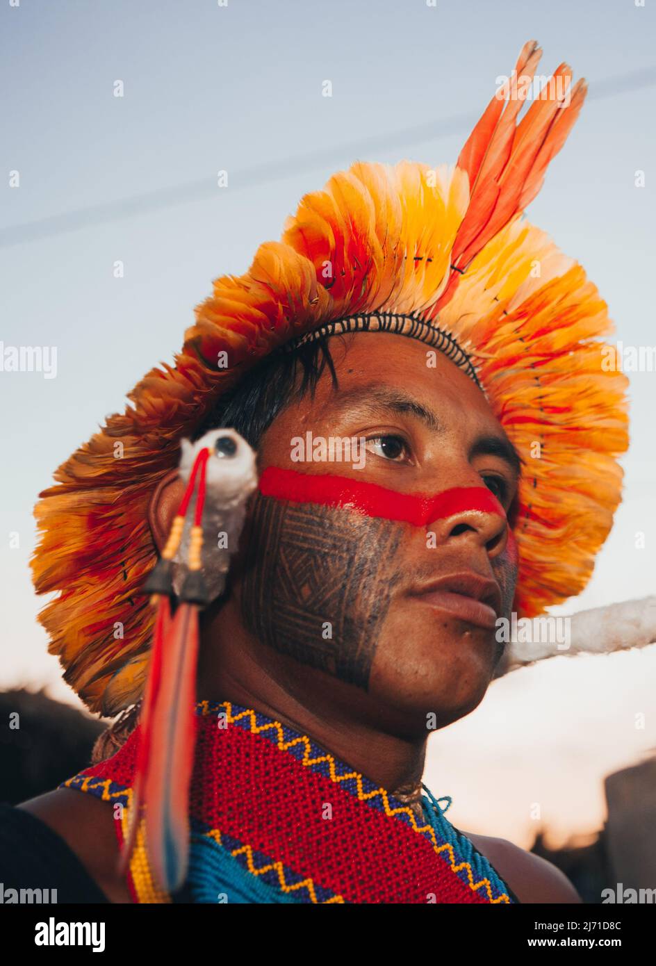 Indigenous man from a Brazilian Amazon tribe wearing feather headdress known as cocar. Xingu River, Amazon, Brazil. 2009. Stock Photo