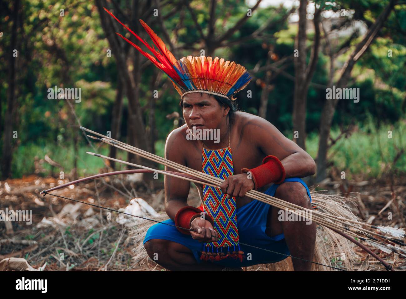 Indigenous man from a Brazilian Amazon tribe wearing feather headdress called cocar. Xingu River, Amazon, Brazil. Jogos Indígenas, 2009. Stock Photo