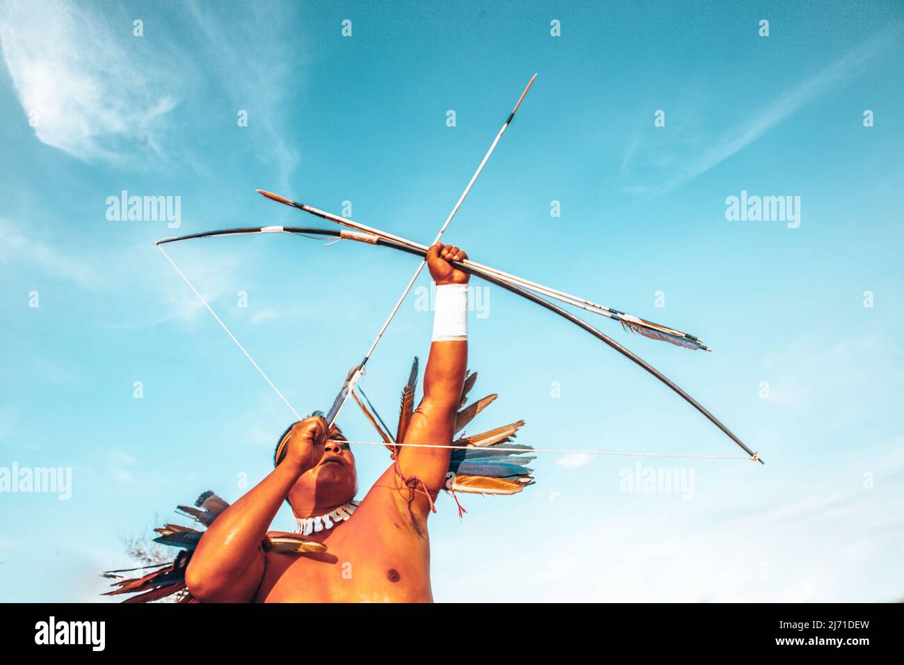 Indian man from an Amazon tribe in Brazil shooting with bow and arrow, wearing adornments. Jogos Indígenas 2009. Stock Photo