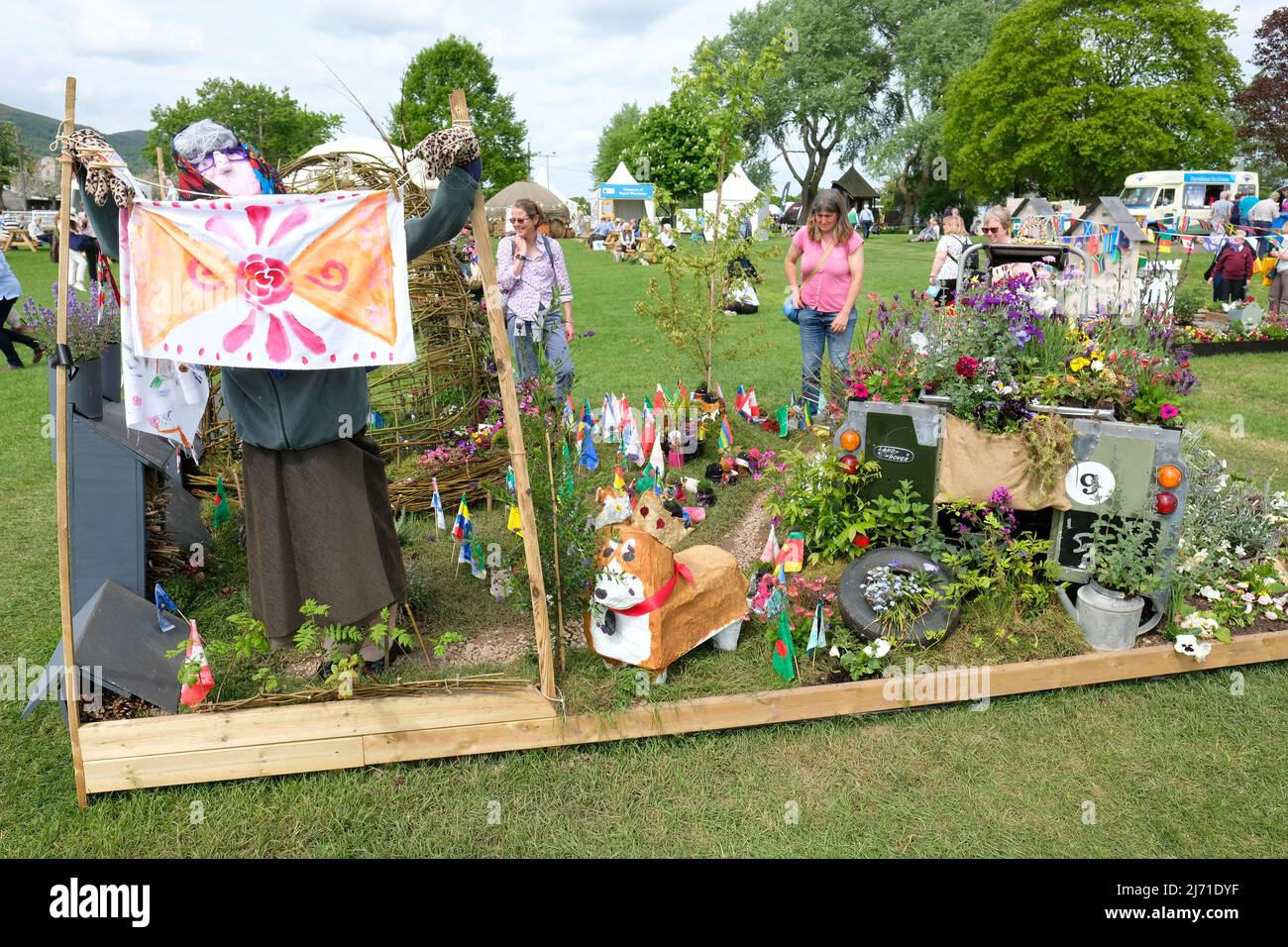 Malvern, Worcestershire, UK – Thursday 5th May 2022 – Visitors enjoy a garden design by local school children called Coronets, Crankshafts and Corgis in honour of the Platinum Jubilee on the opening day of the 35th RHS Malvern Spring Festival of gardening and plants. The show features six show gardens and a Platinum Jubilee Garden. Photo Steven May / Alamy Live News Stock Photo