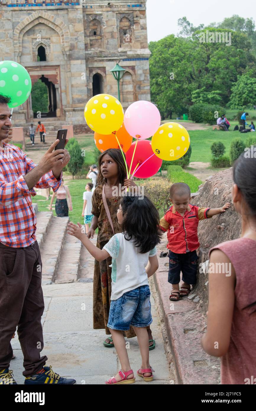 A dark Indian girl is trying to sell balloons, Concept - Child labor Stock Photo