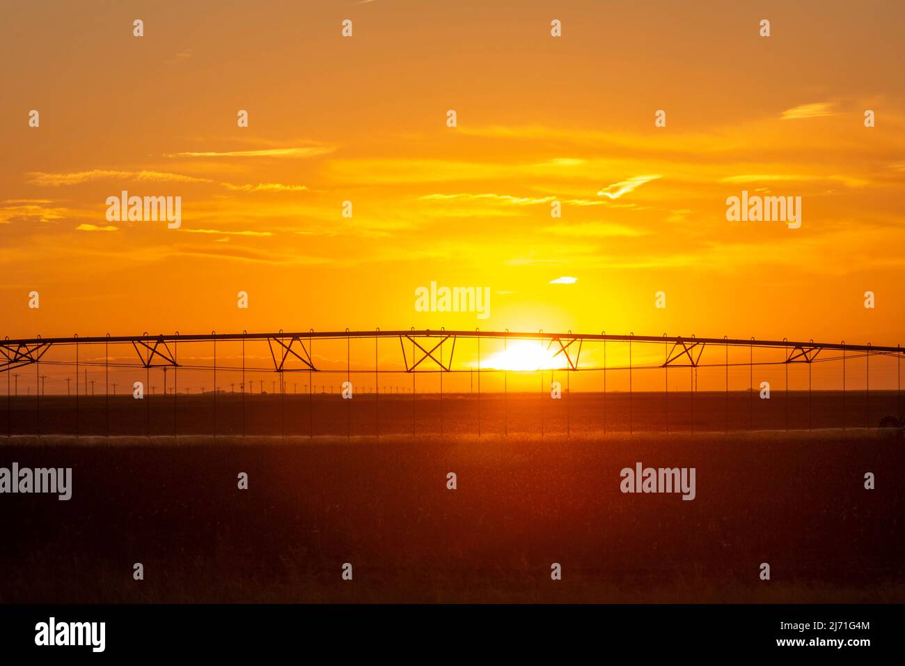 Turpin, Oklahoma - Center pivot irrigation equipment at sunset on a farm in the Oklahoma panhandle. Stock Photo
