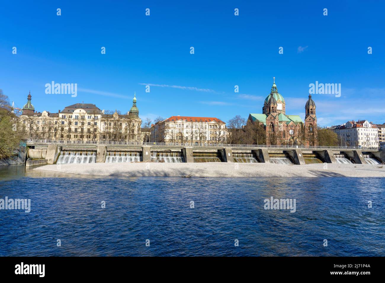 Isar river in Munich with saint Lukas dome cathedral and bridge Stock Photo
