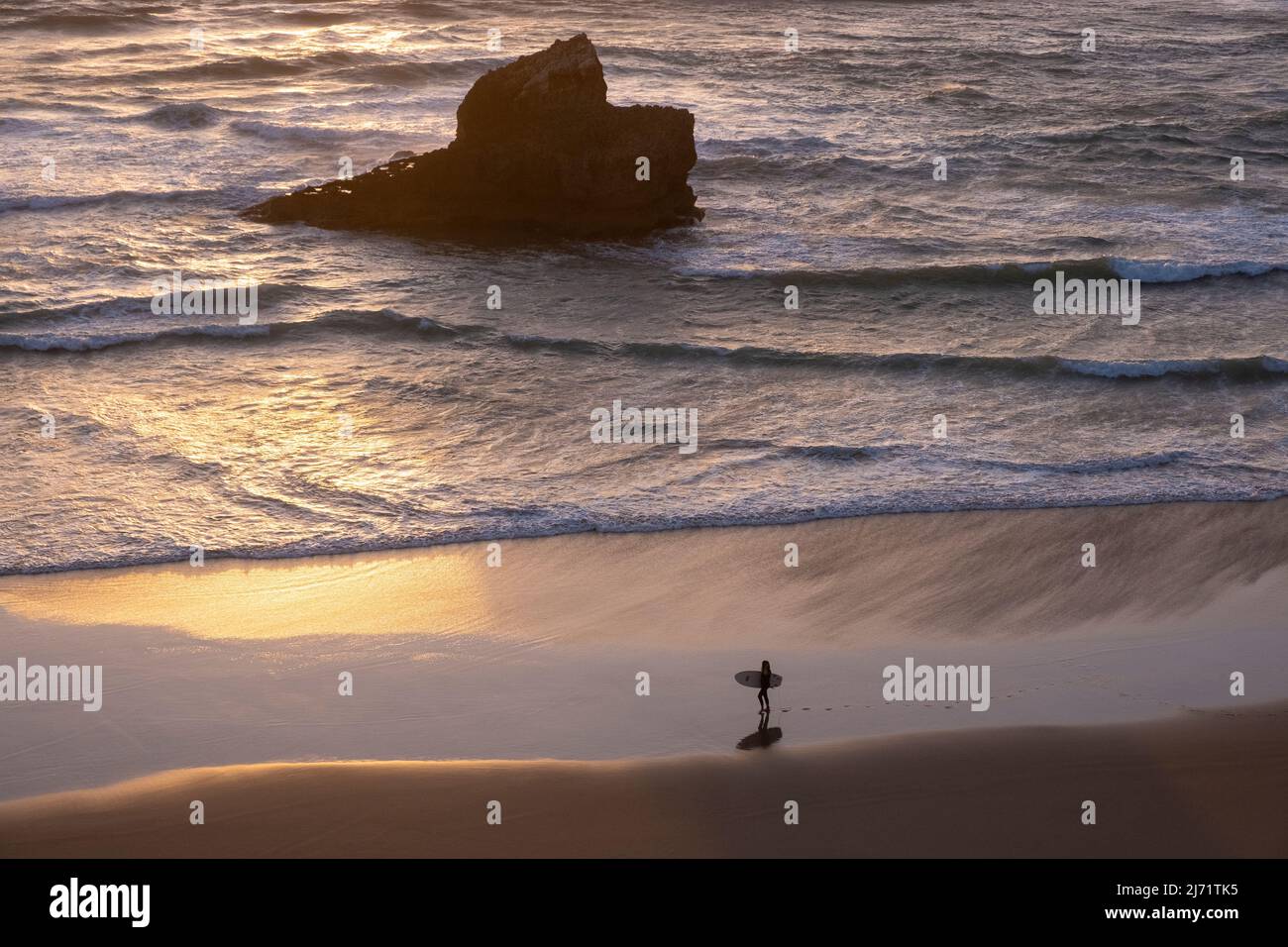 Surfer with surfboard walks along Praia do Tonel, Sagres, Portugal Stock Photo
