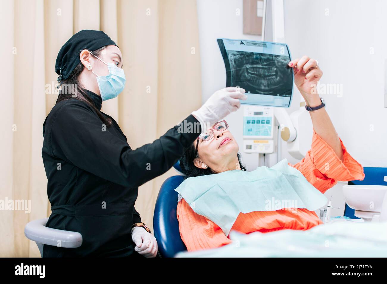 Dentist showing xray to patient, patient looking at xray with dentist