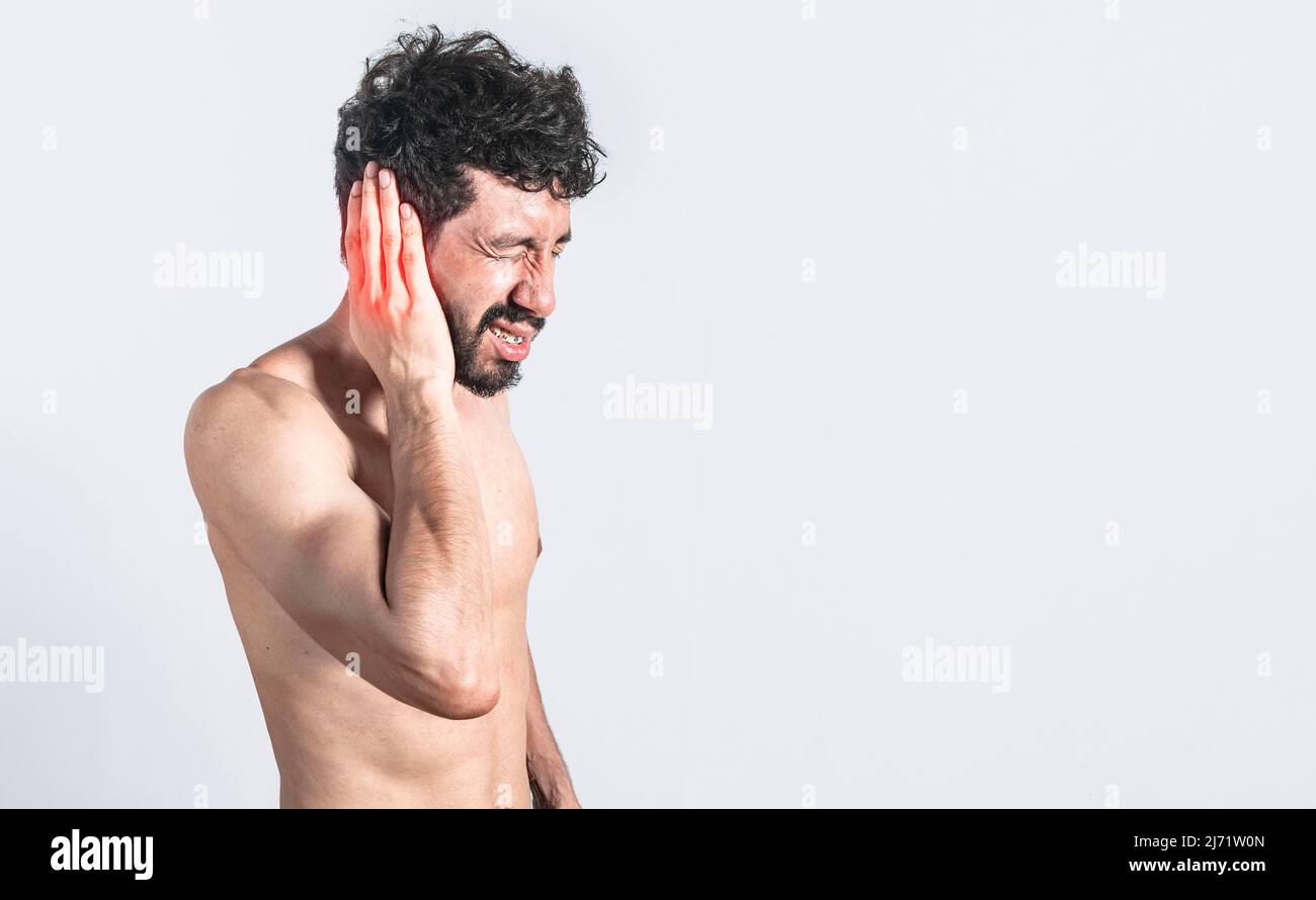 Person with earache on isolated background, man with earache on isolated background, ear disease concept Stock Photo