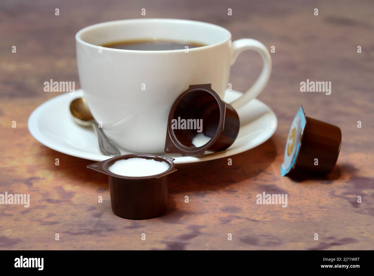Cup of coffee and milk in portion pack Stock Photo