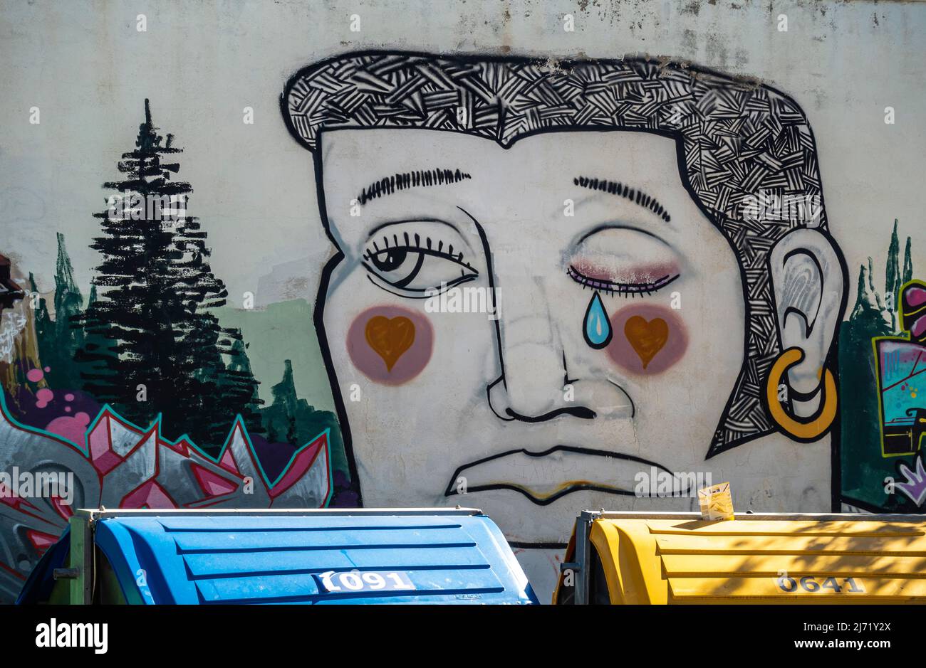 Mural depicting mens head with tear on the wall of Colegio de Santo Domingo de Vistillas Garden. Crying sad man mural in Granada, Andalucia, Spain Stock Photo