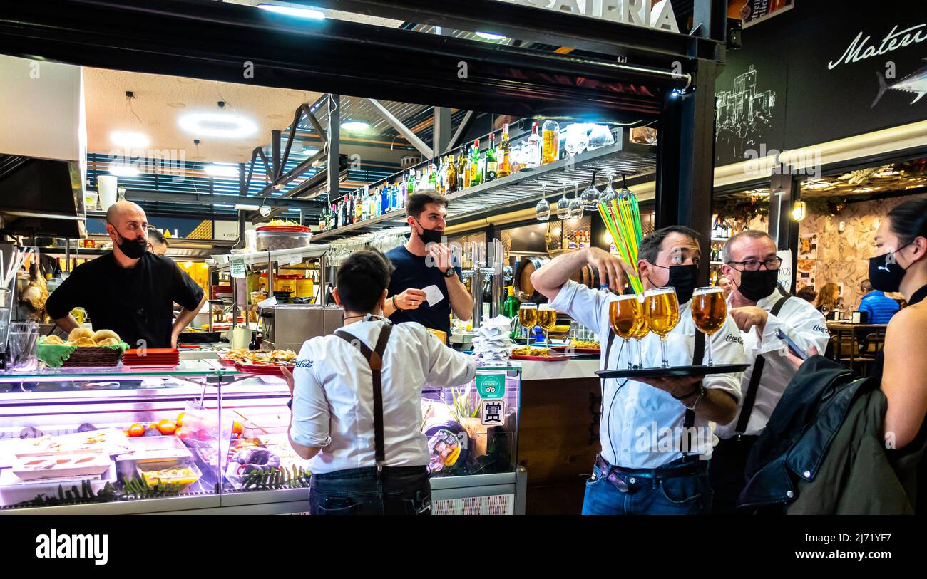 Waiters in face masks serving beer at La Picatería - Mercado San Agustín - St Agustin Market. Granada, Andalucia, Spain Stock Photo