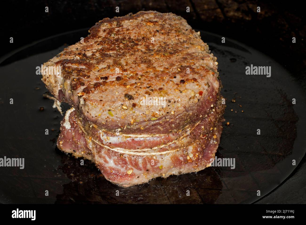 In Form gebundenes und gewuerztes Filet vom Rind, liegt zum Braten in einer  Eisenpfanne Stock Photo - Alamy