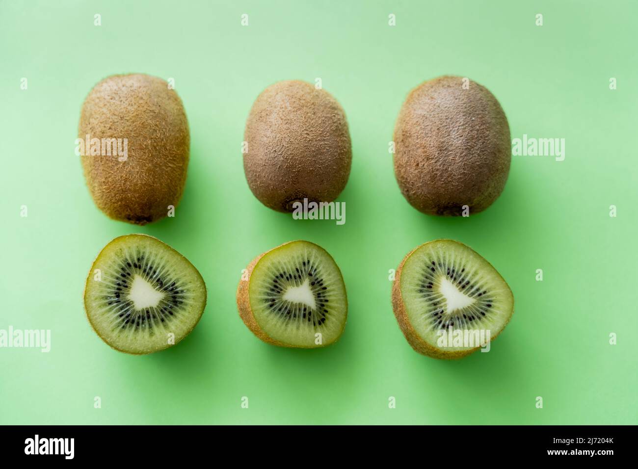 flat lay of organic kiwi fruit on green and pink Stock Photo by  LightFieldStudios