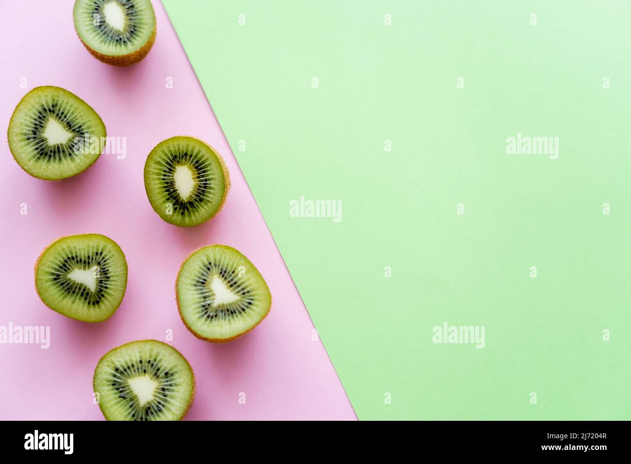 https://c8.alamy.com/comp/2J7204R/top-view-of-fresh-kiwi-fruit-on-green-and-pink-2J7204R.jpg