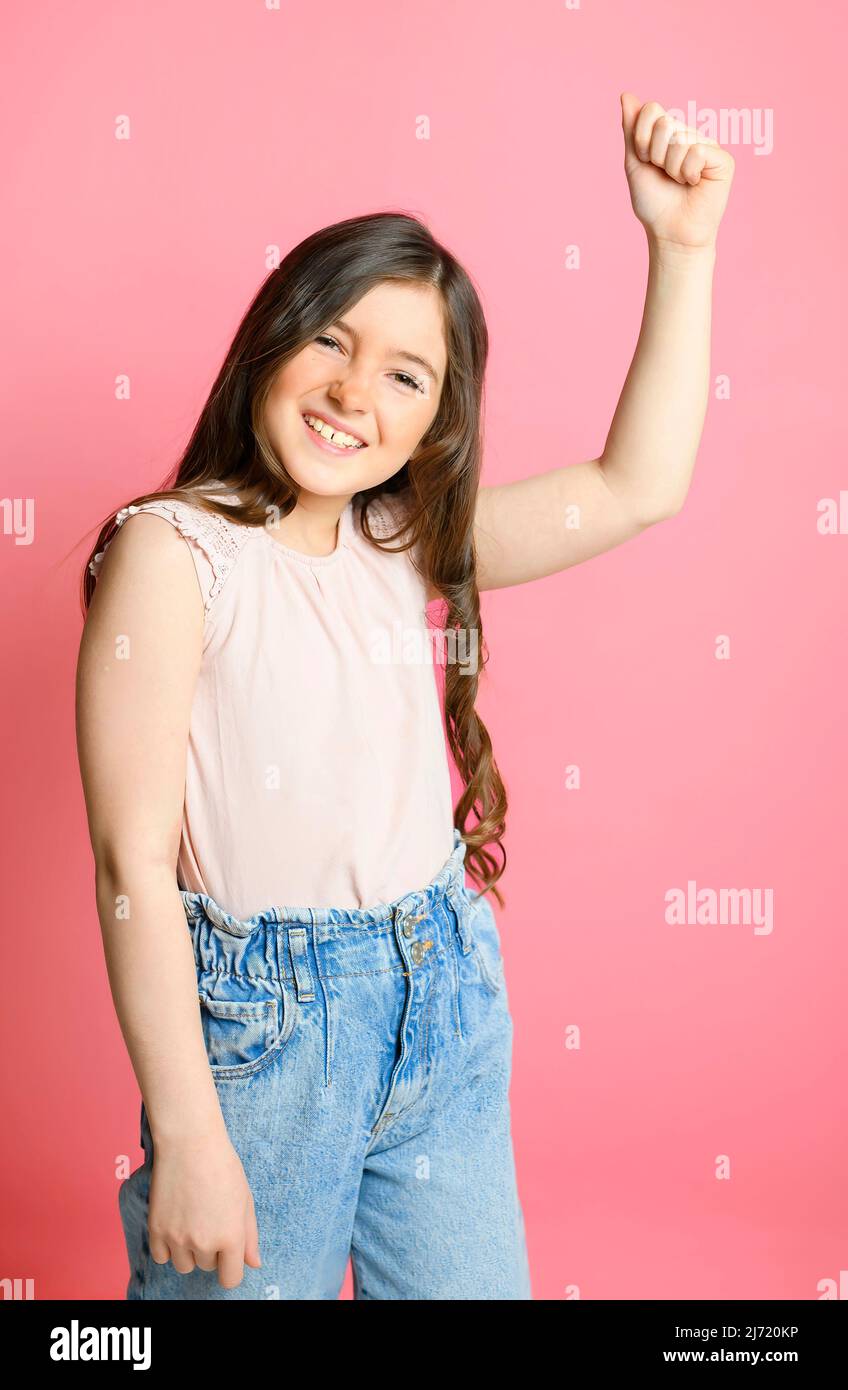 cute child over pink backgroud on studio with hand up Stock Photo