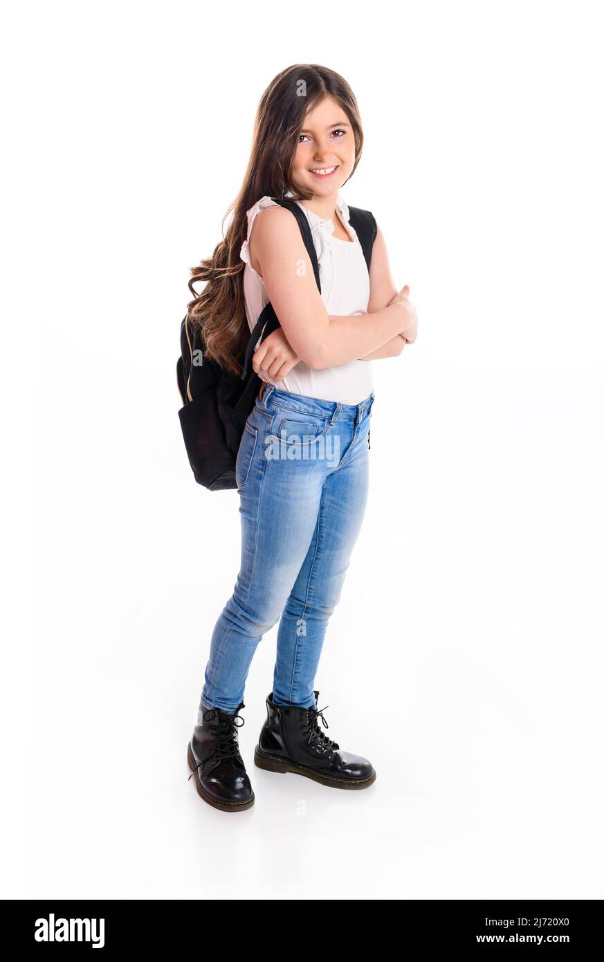 Cute smiling schoolgirl in uniform standing on white background with agenda Stock Photo