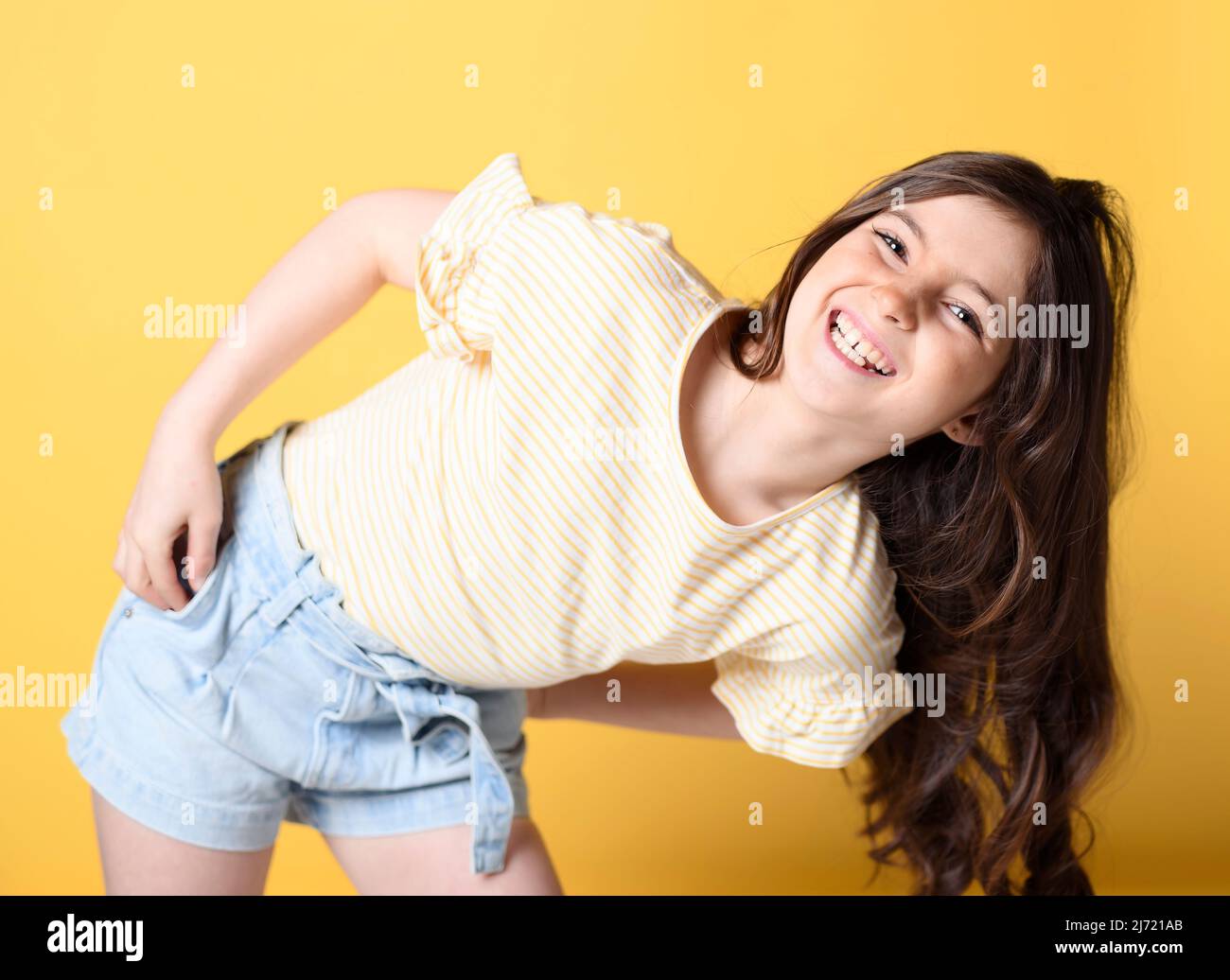 cute child over yellow background on studio Stock Photo
