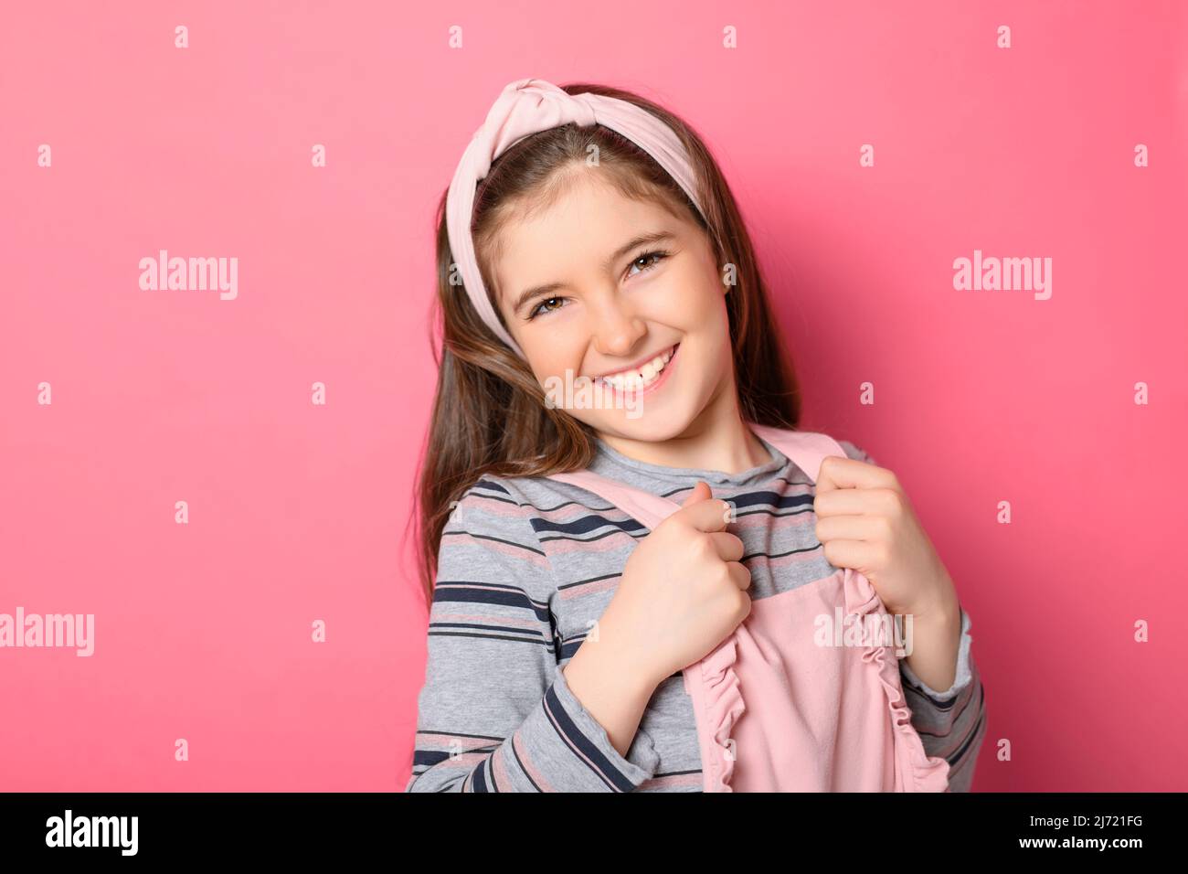 cute child with dungarees over pink background on studio Stock Photo