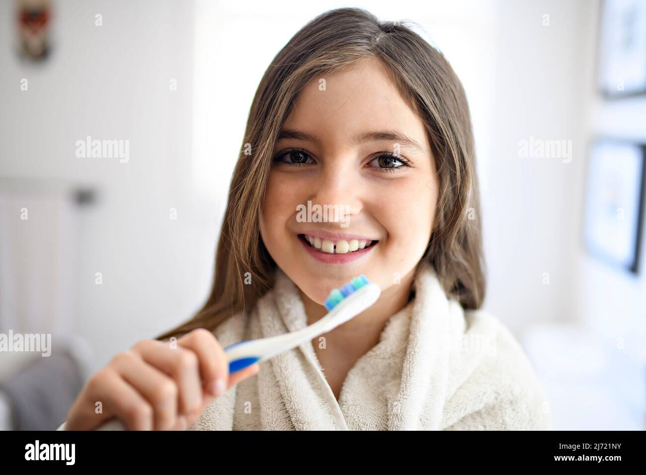 A Little girl brushing teeth in bathroom Stock Photo