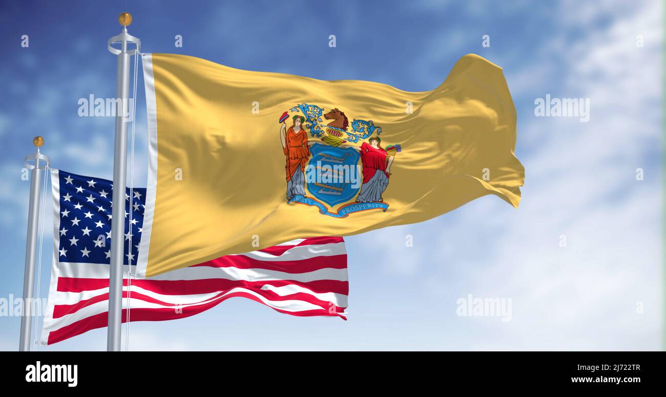 The New Jersey state flag waving along with the national flag of the United States of America. In the background there is a clear sky. New Jersey s a Stock Photo