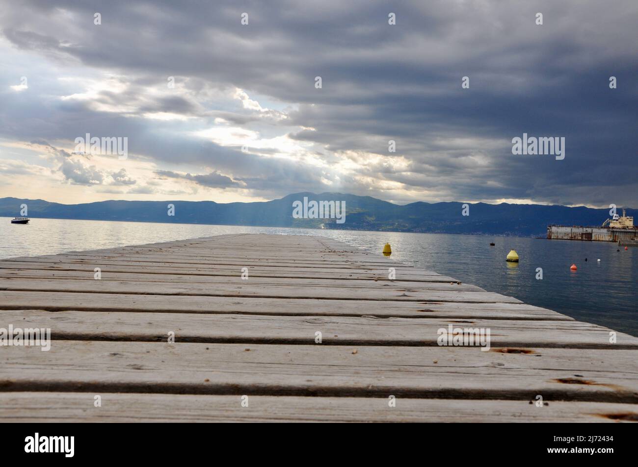 Old wooden texture background of sea pier. Sea Bridge. Empty wooden pier with sea and cloudy sky. Desk space on beach side and sunny day Stock Photo