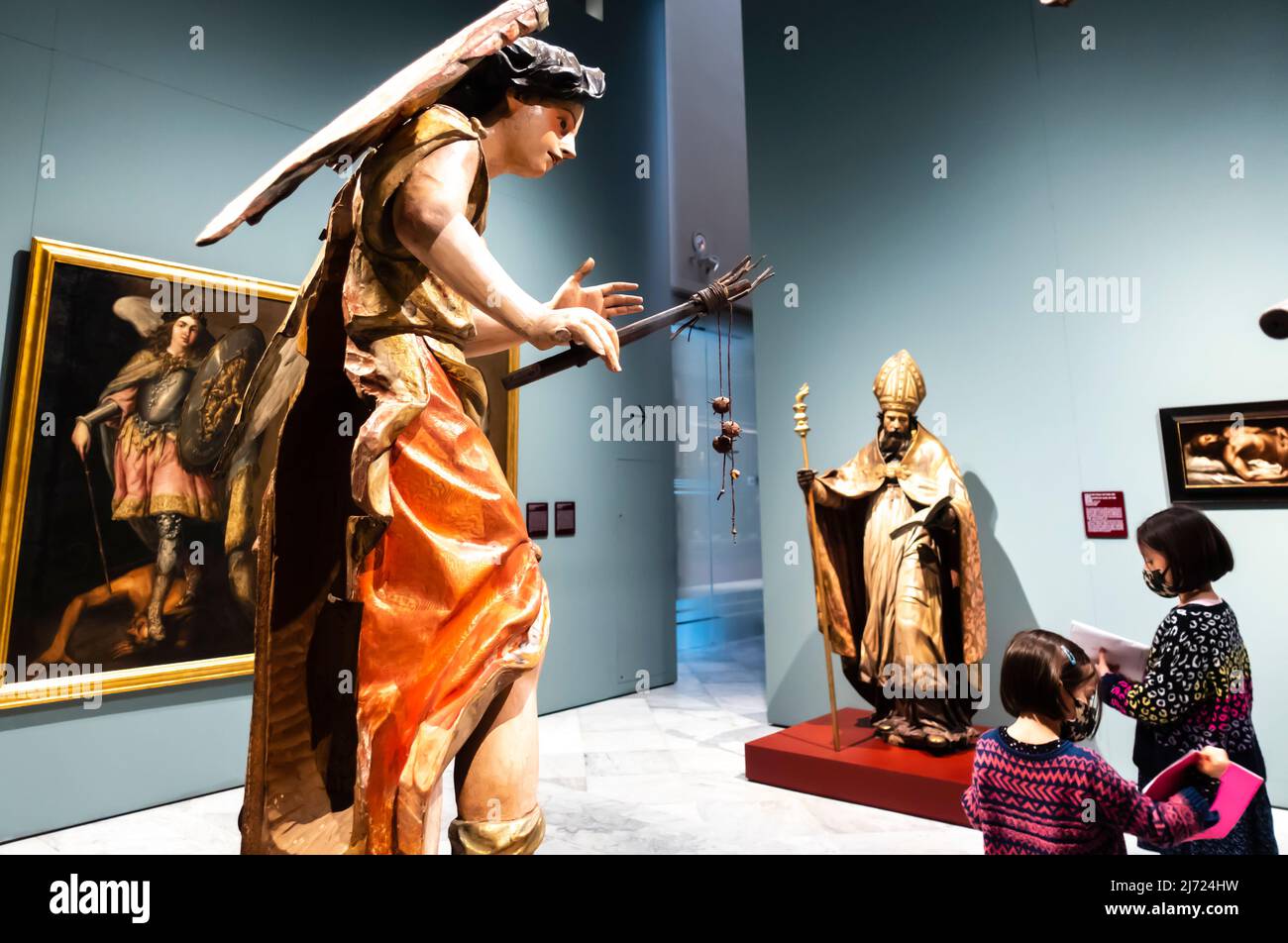 A family, children in face masks in a Baroque sculpture hall in Fine Arts Museum in Seville, Andalucia, Spain Stock Photo