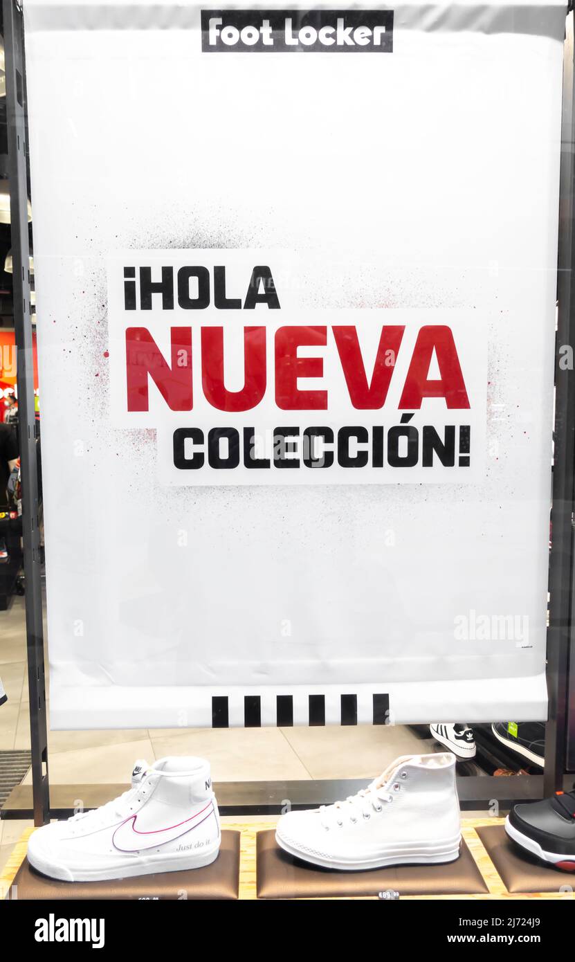 Foot Locker store in Seville - iHOLA nueva coleccion poster on shop window, Sevilla, Andalucia, Spain Stock Photo