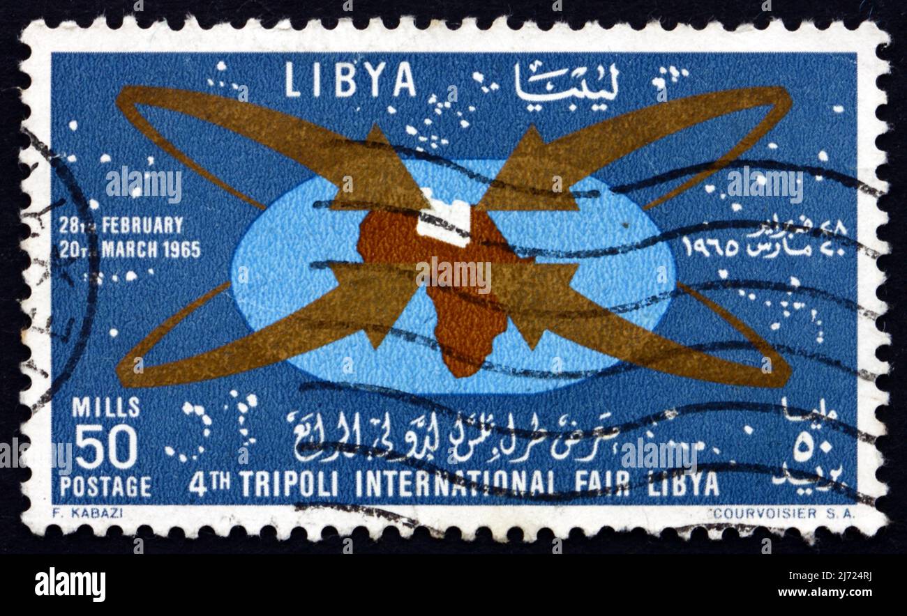 LIBYA - CIRCA 1965: a stamp printed in Libya shows Map of Africa with Libya, Fair Emblem, 4th International Fair, Tripoli, circa 1965 Stock Photo