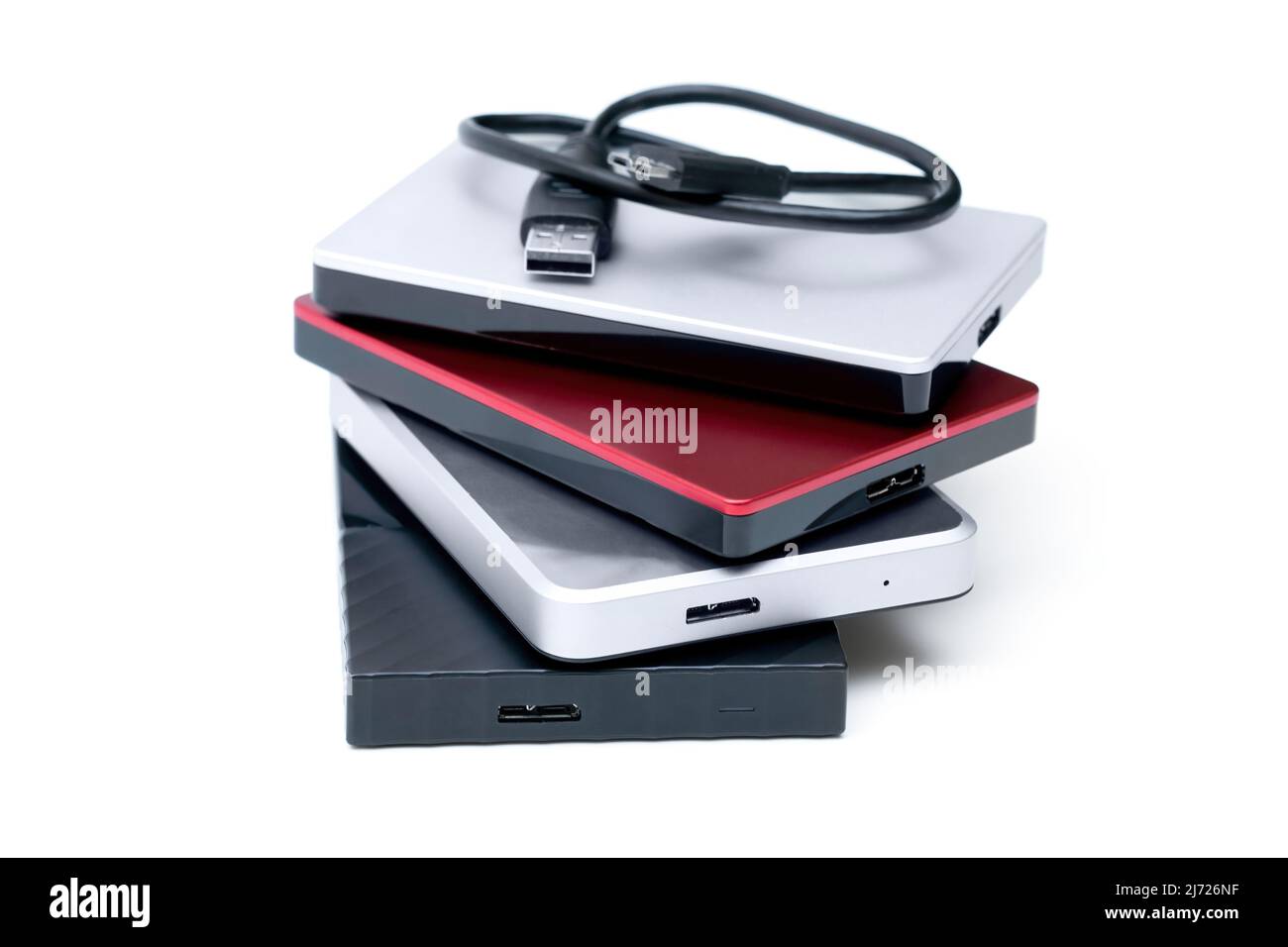 Pile of four external portable hard disk drives with a connection cable