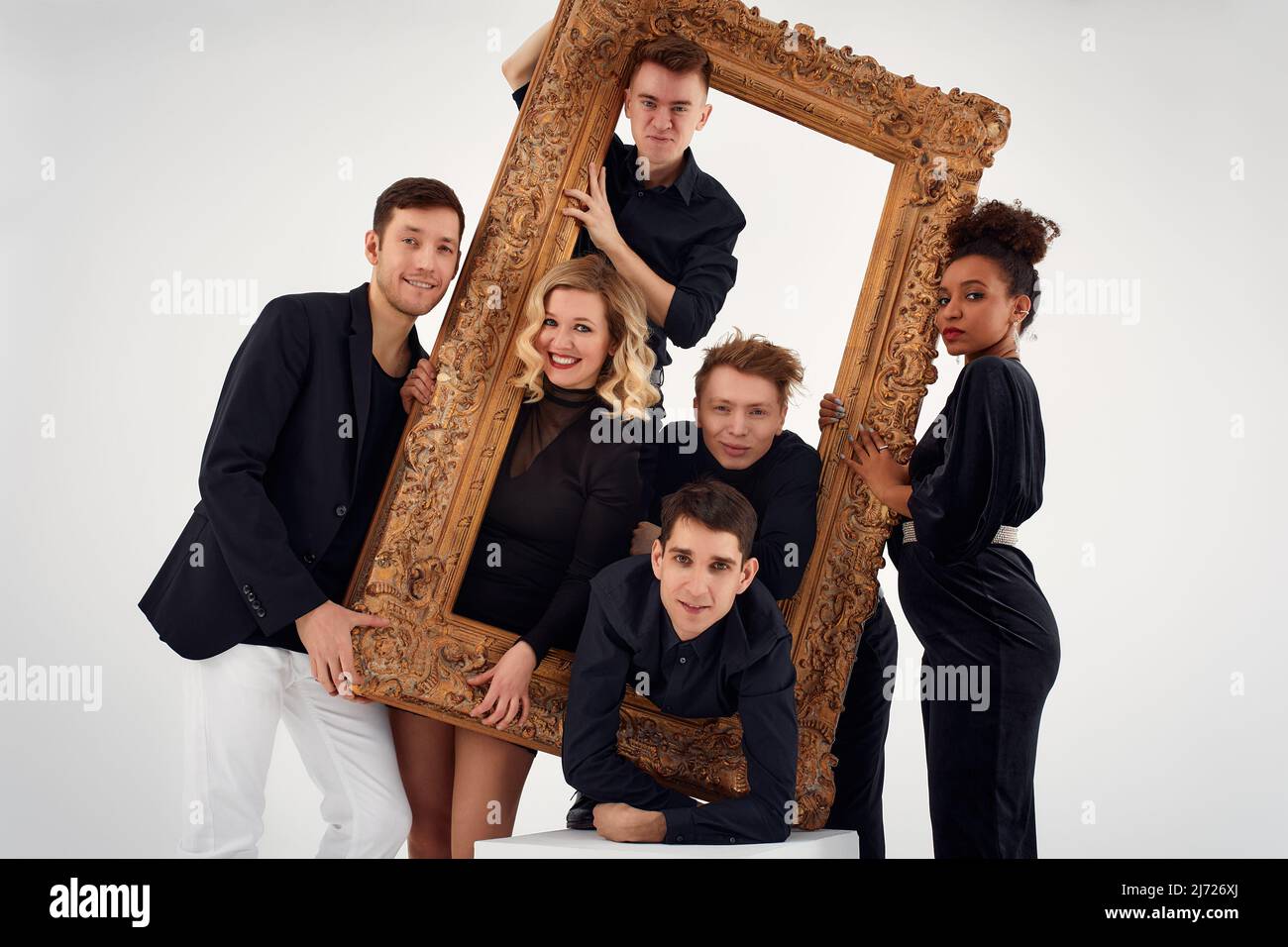 studio portrait of Beautiful young diverse group of friends isolated on white background in the frame for a picture, goofy face, good mood Stock Photo