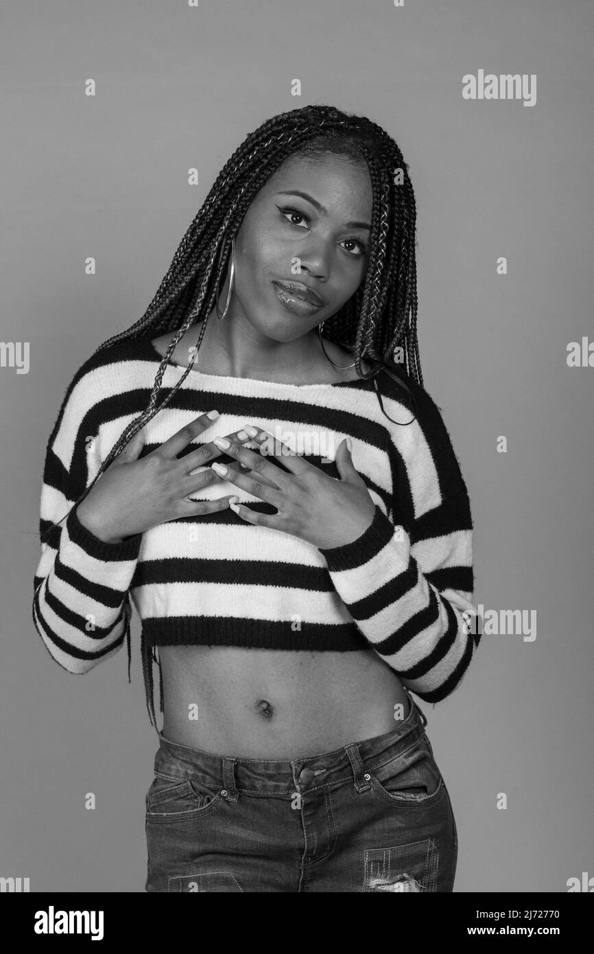 Young Black Girl in striped shirt with exposed midriff posing in studio Stock Photo