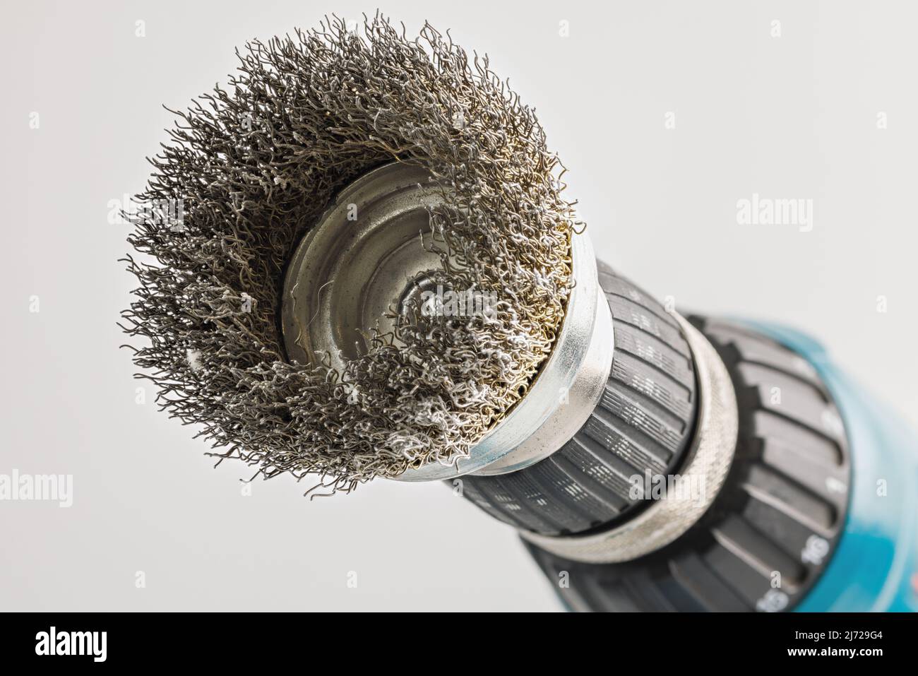 Hand drill with round steel brush on white background Stock Photo Alamy