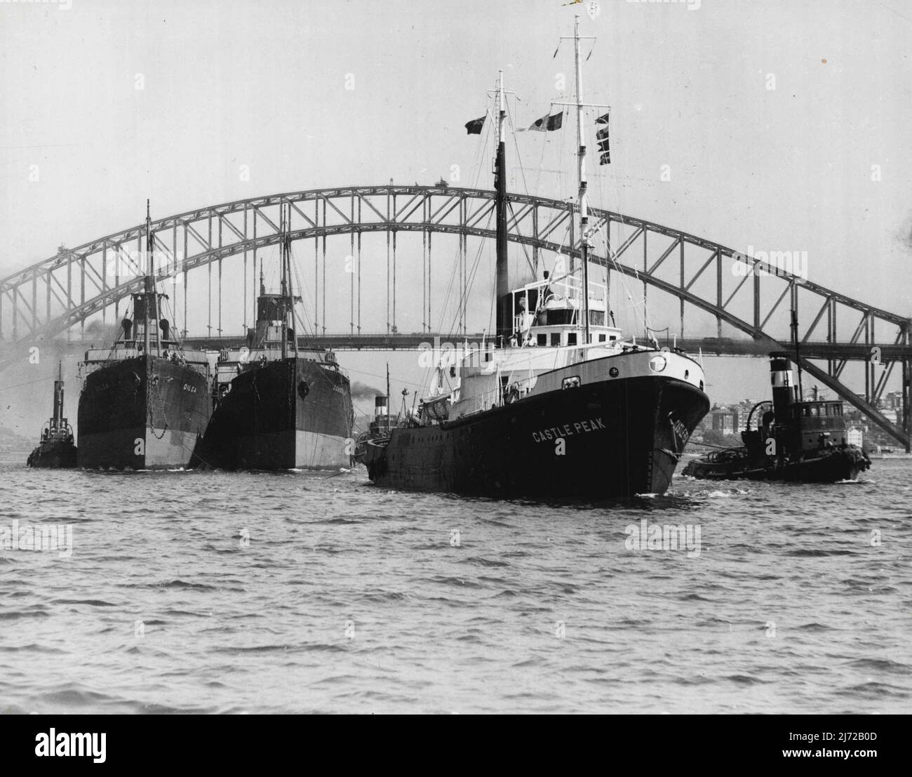The ocean-going tug Castlepeak, with the former interstate freighters Dundula and Diga in tow, leaving Sydney yesterday for Japan, where the freighters will be scrapped. February 28, 1953. Stock Photo