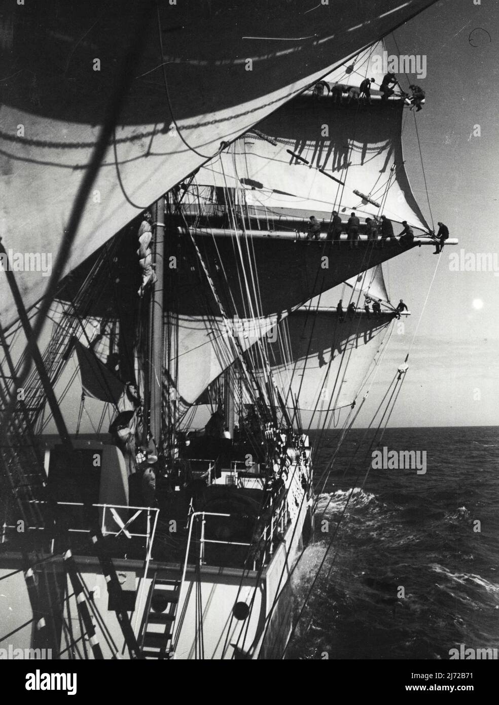 Aboard A Windjammer -- Members of the crew rigging was taken from a lifeboat slung out from the side specially for the photographer. Special photograph taken aboard the four-masted barque Abraham Rydberg winner of the race from Australia, as she set sail from Falmouth to complete her voyage to Ipswish. May 7, 1934. (Photo by London News Agency Photos Ltd.) Stock Photo
