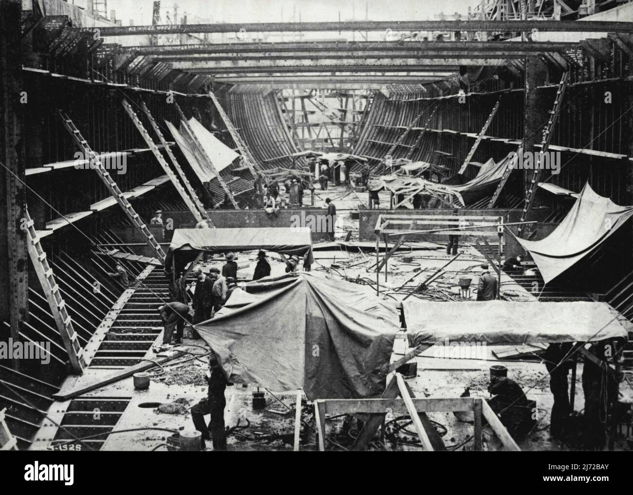 United Nations - Prime Minister King has announced that this year Canada. will, for the first time in history, be building almost as many merchant ships as the United Kingdom. These vessels are, 95 per cent Canadian in workmanship and material. Some idea of the cargo space of these vessels may be gained by this photo of the interior of a hull under construction. When completed, this ship will be capable of carrying the following cargo in one voyage; enough flour, cheese, bacon, ham, canned and dried fruits to feed 225,000 persons in Britain for a week; 2,150 tons of steel bars and slabs; enoug Stock Photo