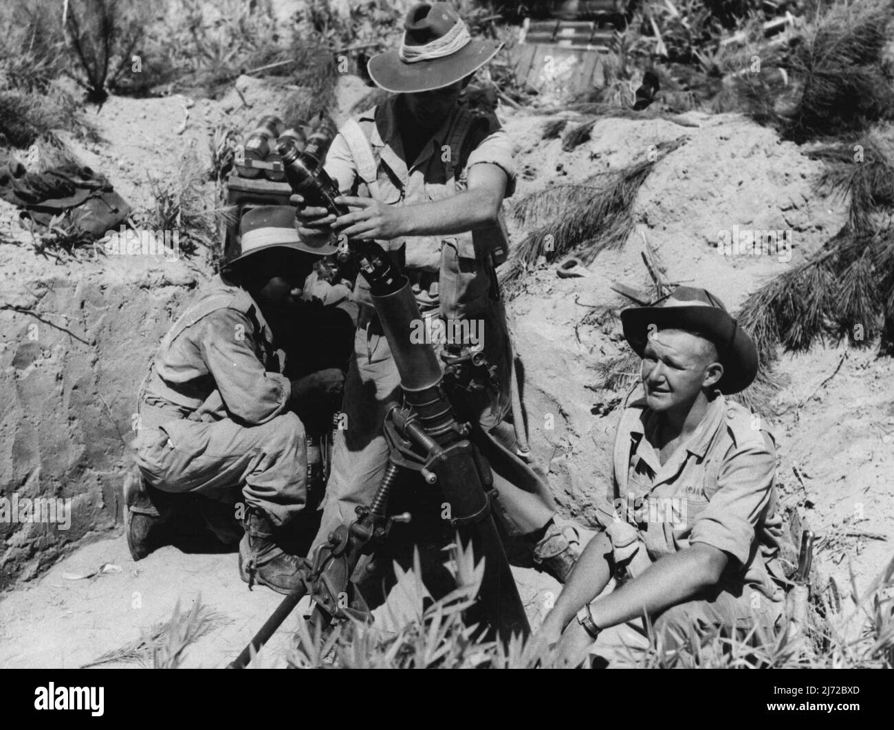 A Mortar Gun crew go into action during training at Haramura Japan, L to R: Pte Houston E.F. of Queenstreet Mt Morgan Queensland; Pte D.R. of Dairy Road Ingelburn N.S.W. and Pte Holford J.E. of 14 Andrews Street Windsor Victoria. The British Commonwealth Occupation Force in Japan is being raised to war time strength and 3 Bn Royal Australian Regiment has been training intensively for the type of terrain which will have to be covered in Korea. September 13, 1950. (Photo by Public Relations Section, HQ BCOF Japan). Stock Photo