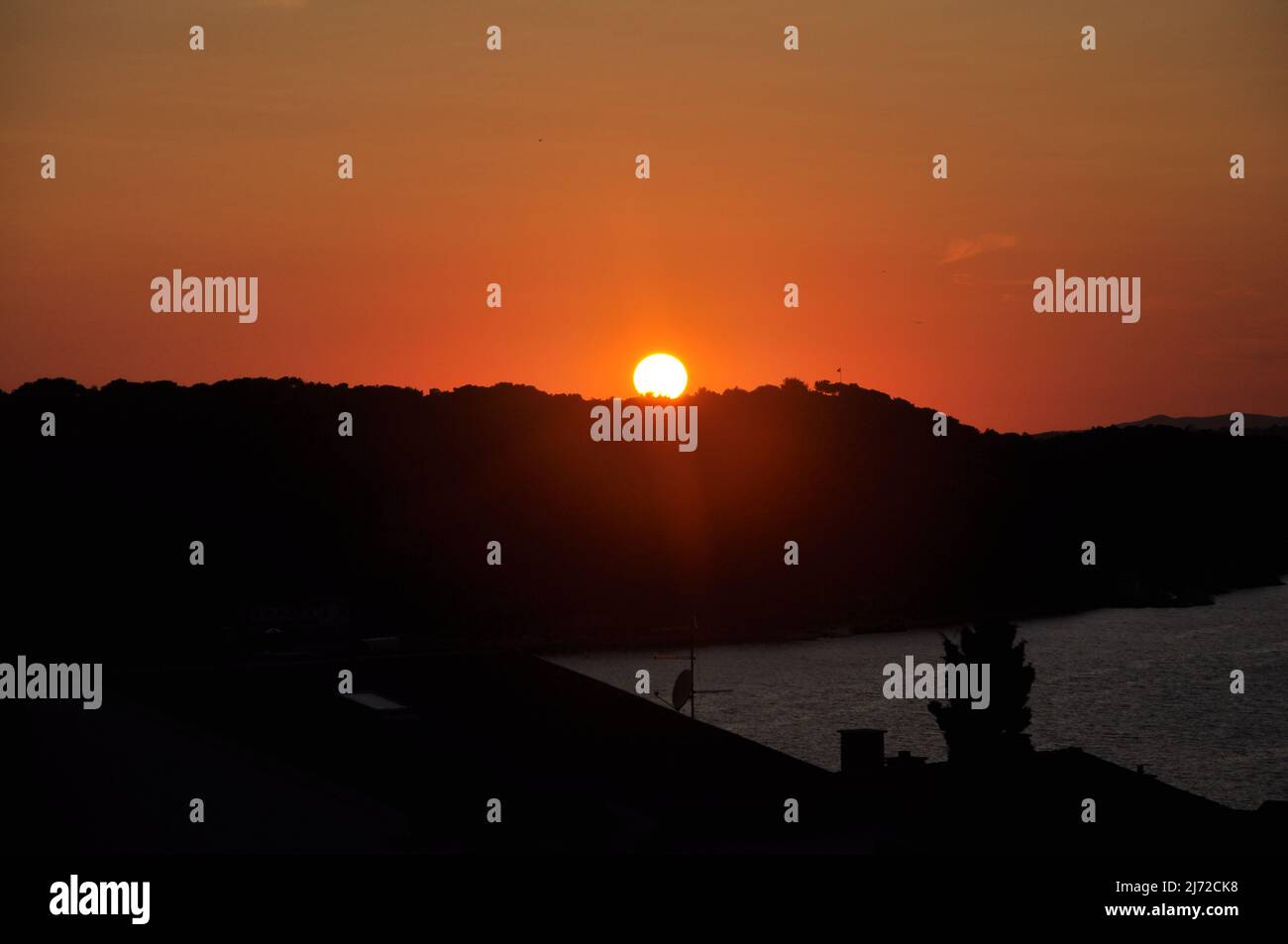 Red sunset behind Losinj island hill, Croatia Stock Photo