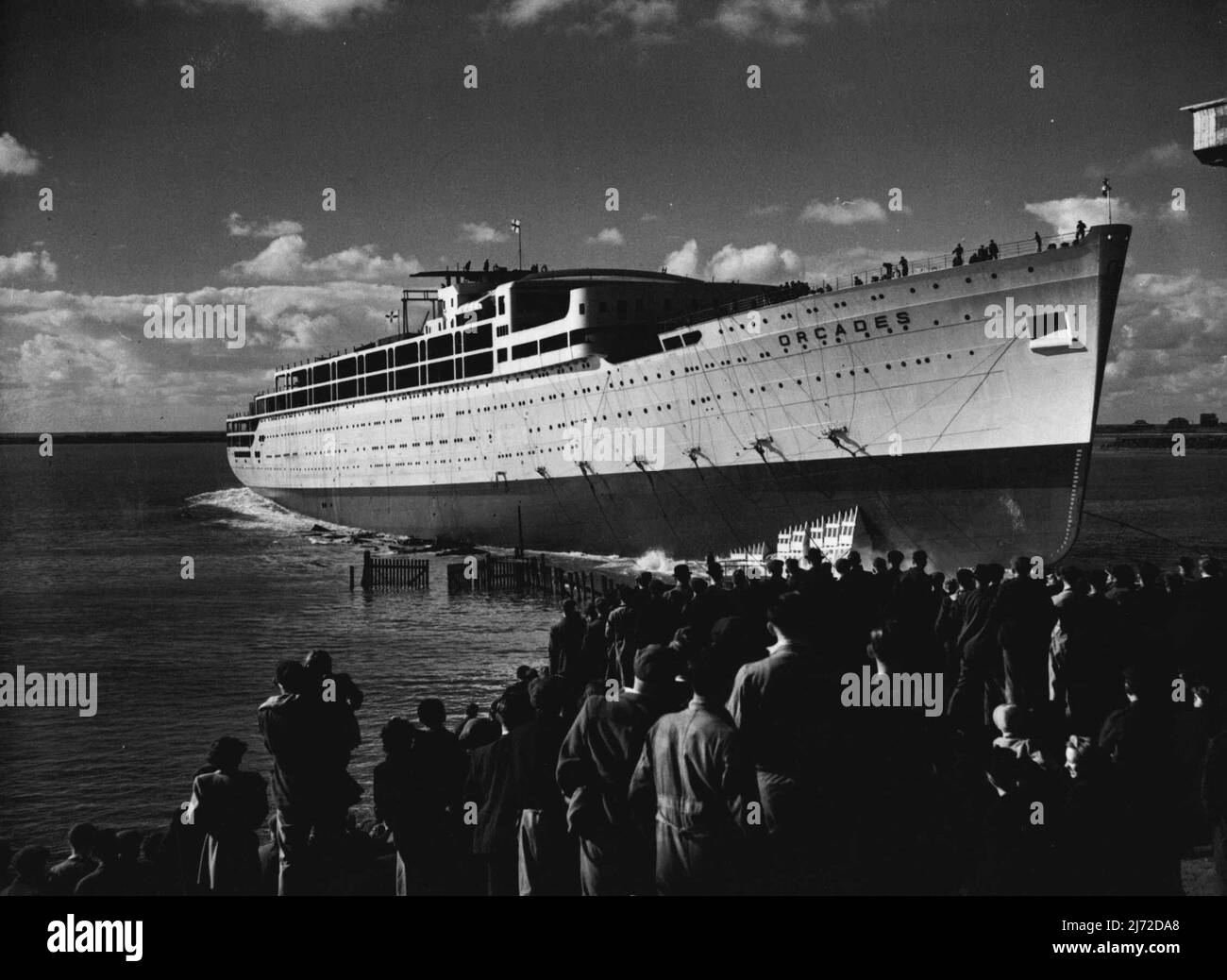 Largest Post-War Liner Launched -- The 31,000-ton liner 'Orcades', built by Vickers-Armstrong for the Orient Line at their Barrow-in-Furness Yards, was launched yesterday by Lady Morshead, wife of the Sydney Manager of the Line. The 'Orcades' is the biggest merchant ship in the world to be launched since the war, and has been built for the Australian trade at a cost of £3,000,000. It will carry over 1,500 passengers and 608 crew. The picture shows tugs fussing round the ship to take her out to the fitting out yards after the launch. October 15, 1947. Stock Photo