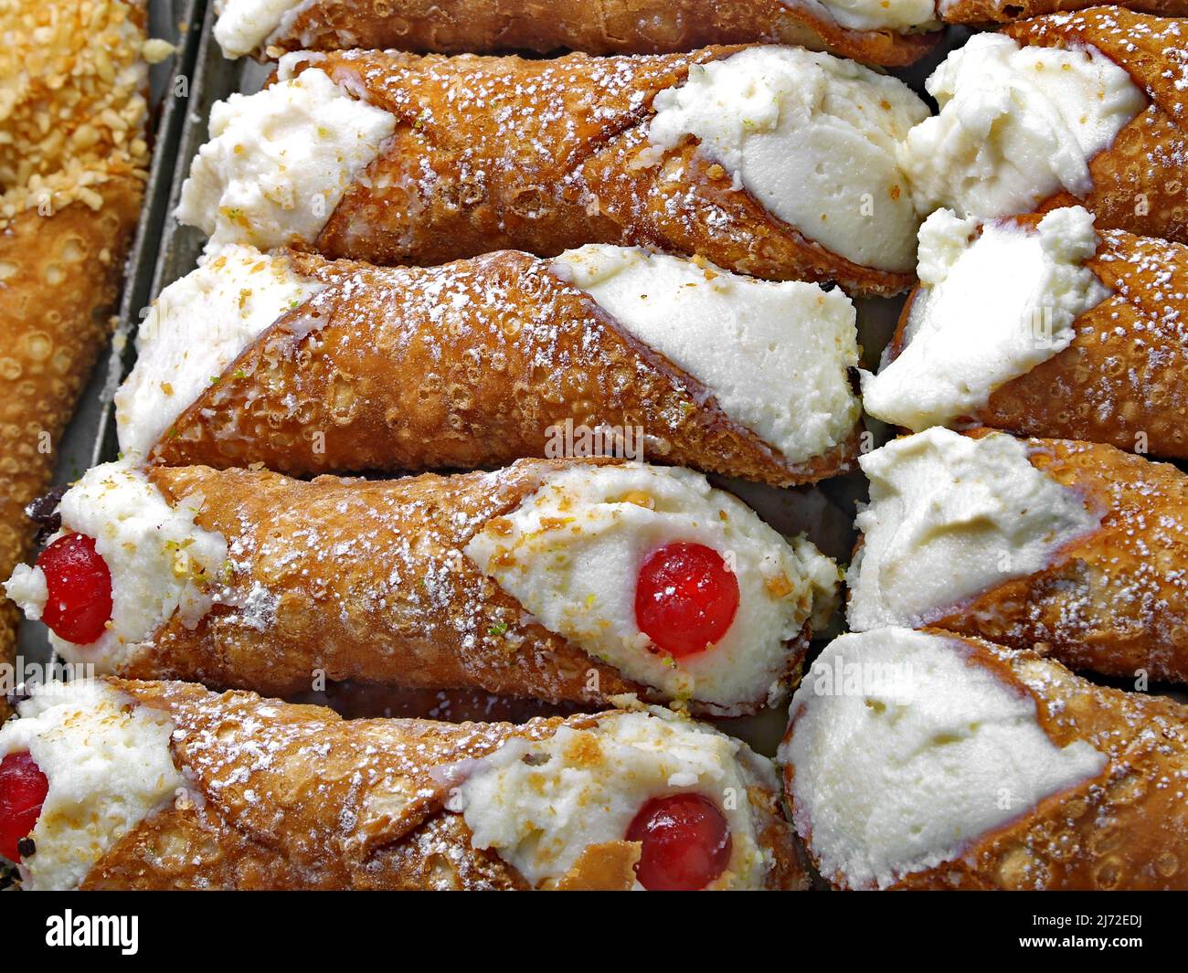 stuffed pastries with red cherry in pastry called CANNOLI SICILIANI in