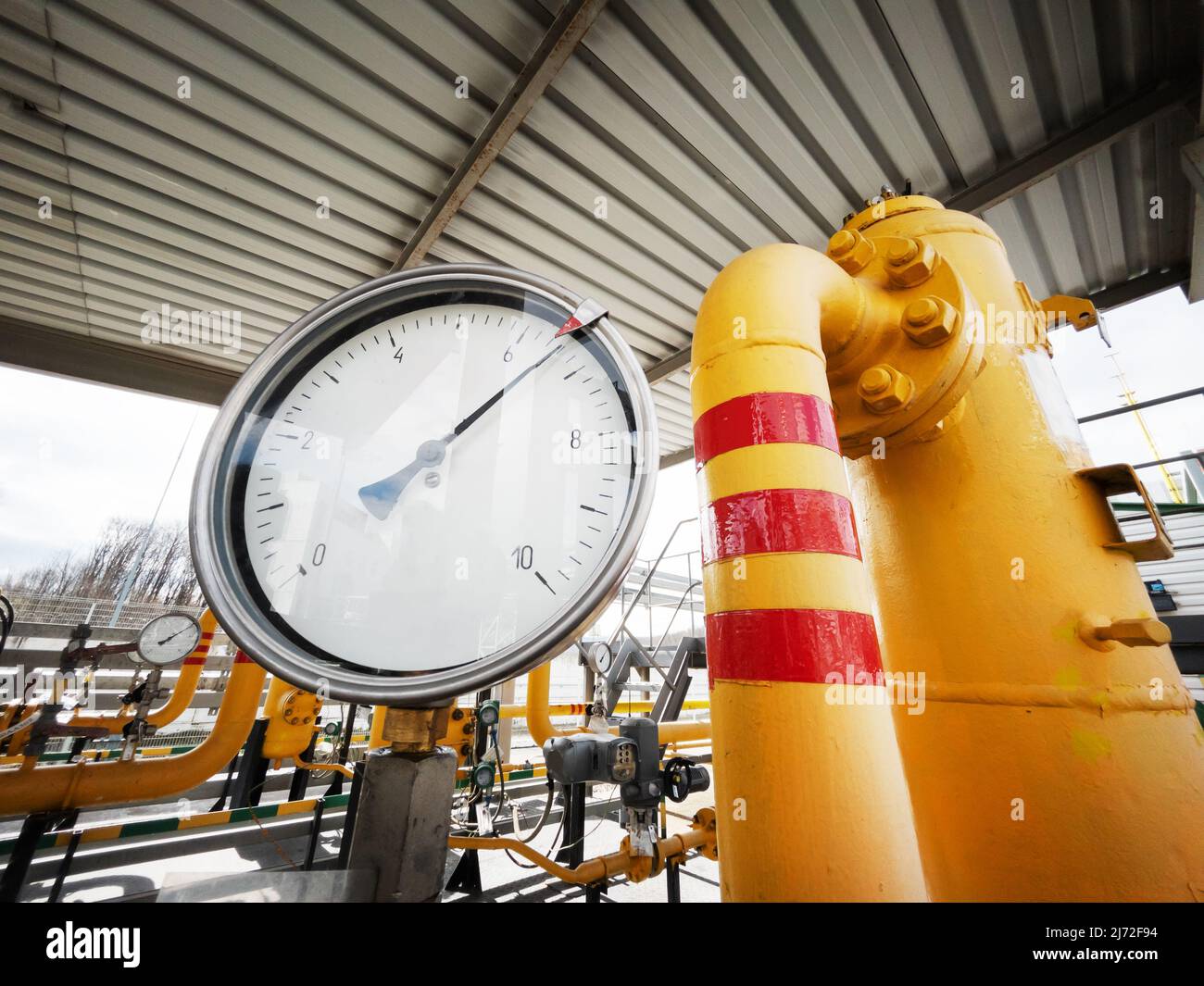Yellow gas pipeline with a large pressure gauge for measuring gas pressure to generate energy Stock Photo