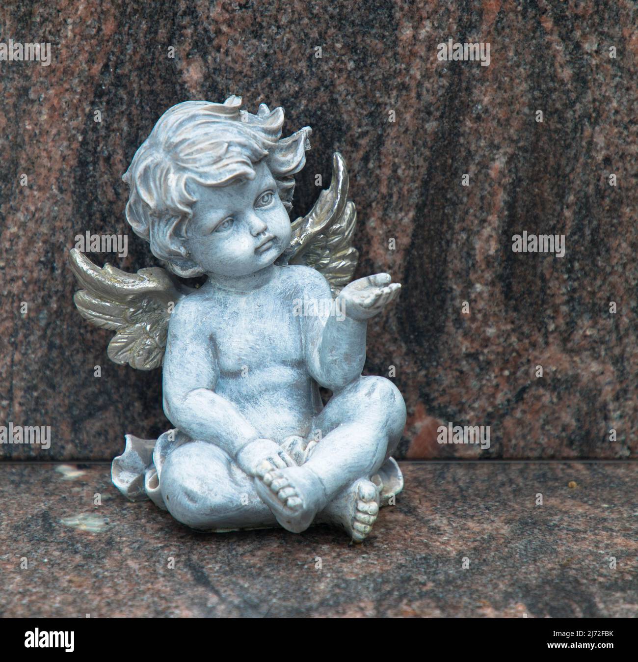 Close up of a white angel. Moment of grief at the end of a life. Last farewell. Funeral concept. Stock Photo