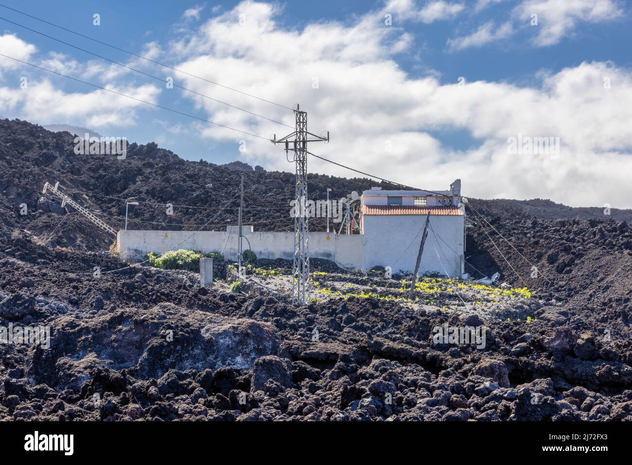 House been spared while fully surrounded by new lava field from recent erupted volcano Cumbre Vieja at la Palma Stock Photo
