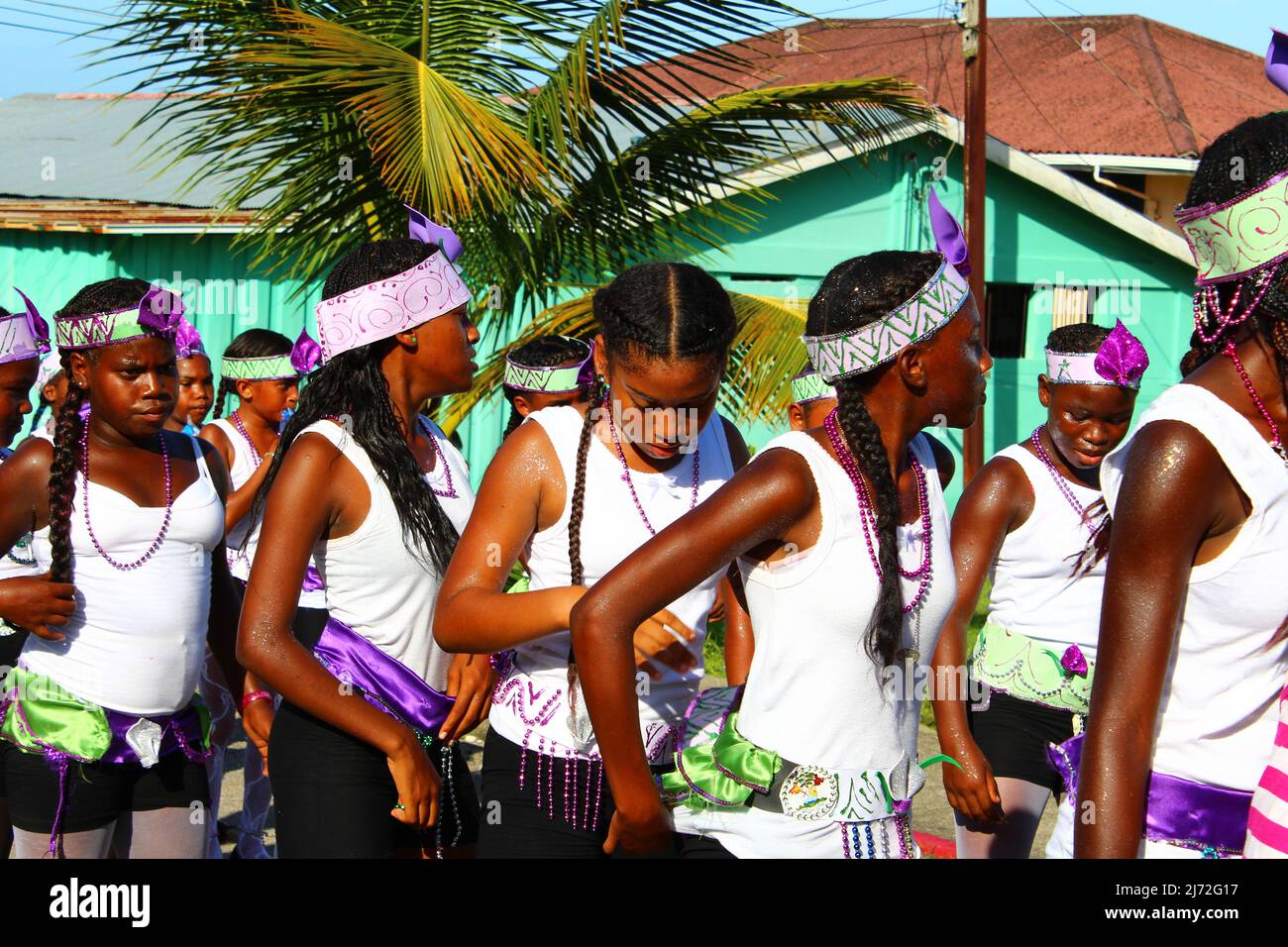 PUNTA GORDA, BELIZE - SEPTEMBER 10, 2015 St. George’s Caye Day celebrations and carnival with girls standing in black, white and purple with a green Stock Photo