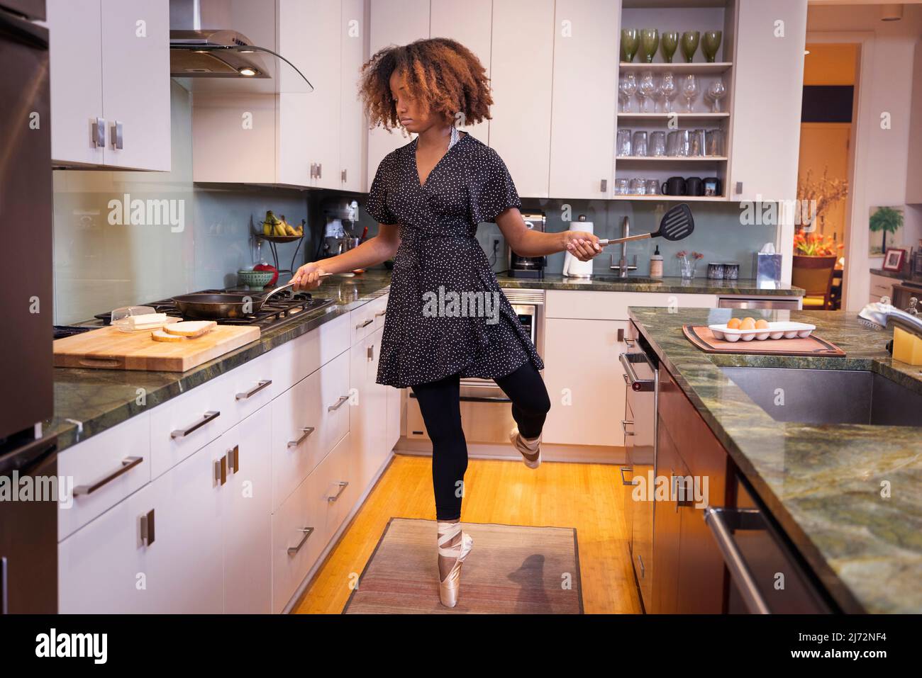 Ballet dancer cooking in a residential kitchen Stock Photo