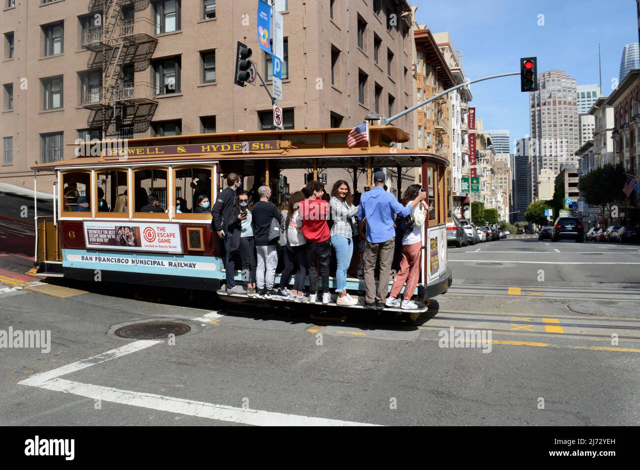 A vintage streetcar stops at an intersection to pick up and drop off