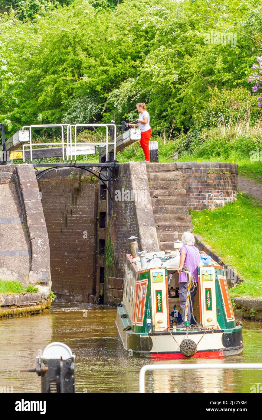 Man And Woman On A Canal Narrowboat Holiday Passing A Through Lock 65 Wheelock Top Lock On The